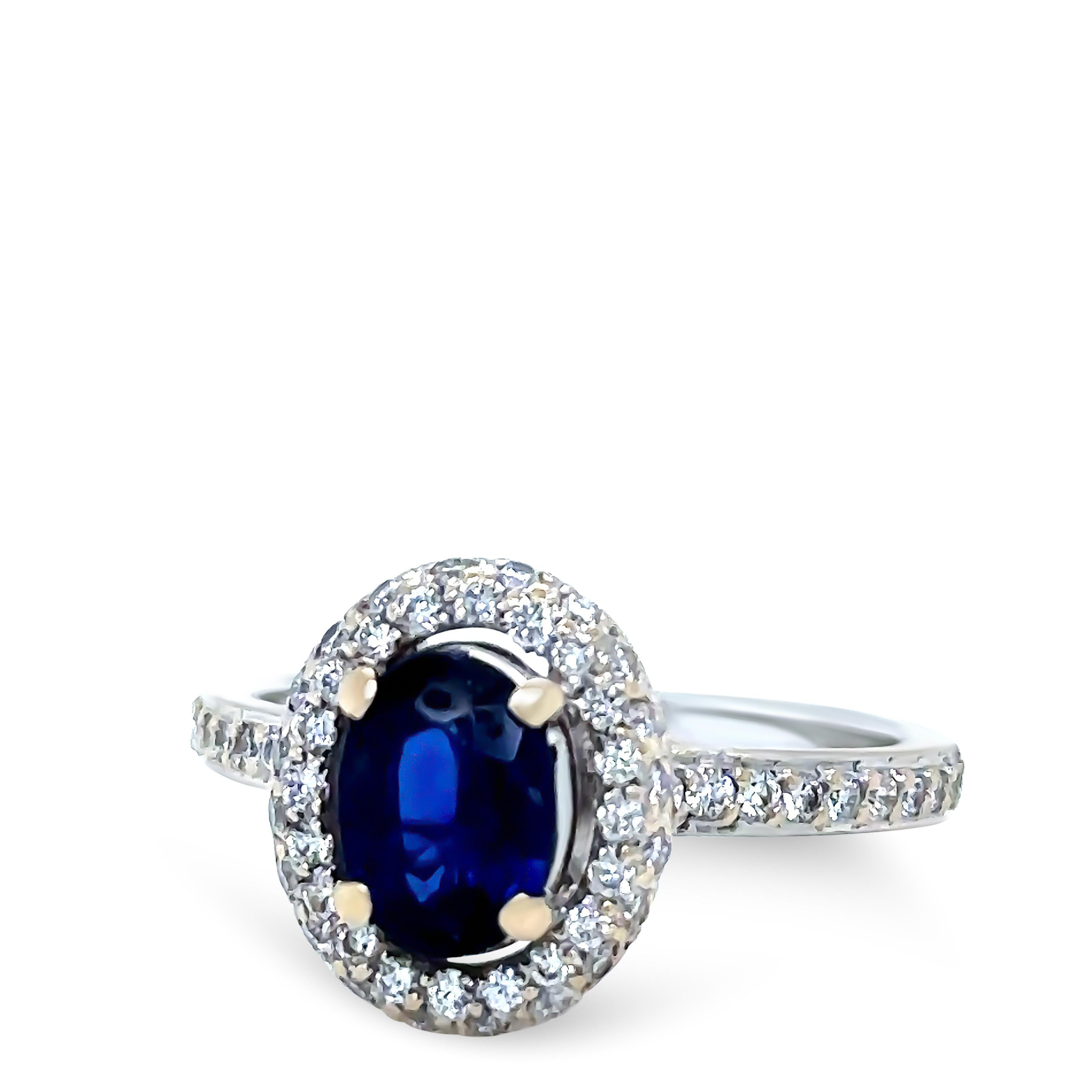 A Bespoke Sapphire & Diamond Ring, made of 18ct White Gold. Featuring a Oval Cut Blue Sapphire in a 4 claw setting, estimated 0.95ct. Additionally set with 60 Round Brilliant Cut Diamonds in claw settings, G/H Colour, VS Clarity with a weight of