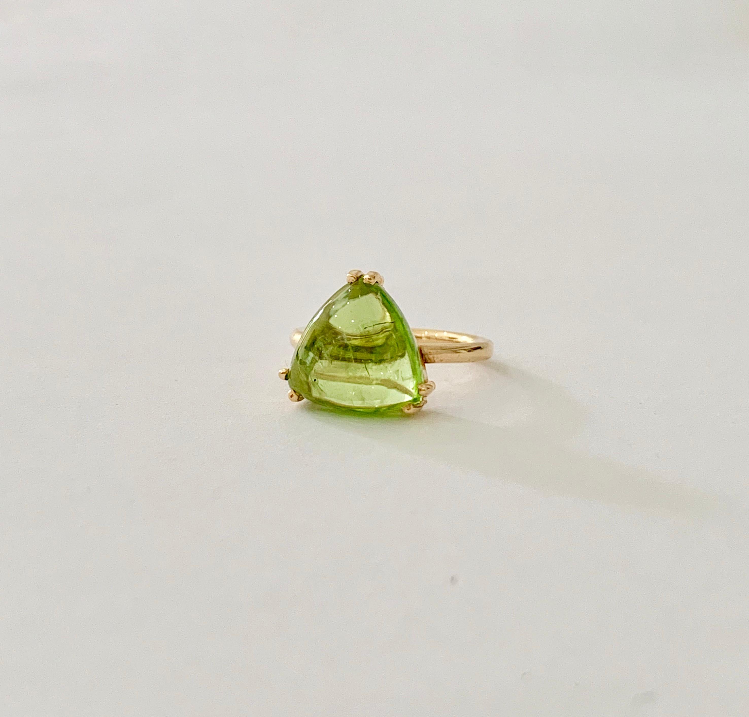 This Bespoke Peridot* ring was designed using a CAD especially to compliment the cabochon* trillion cut stone and, therefore,  making it totally unique.  The Peridot is a luxurious light green with a jelly effect from the cabochon cut.  The stone