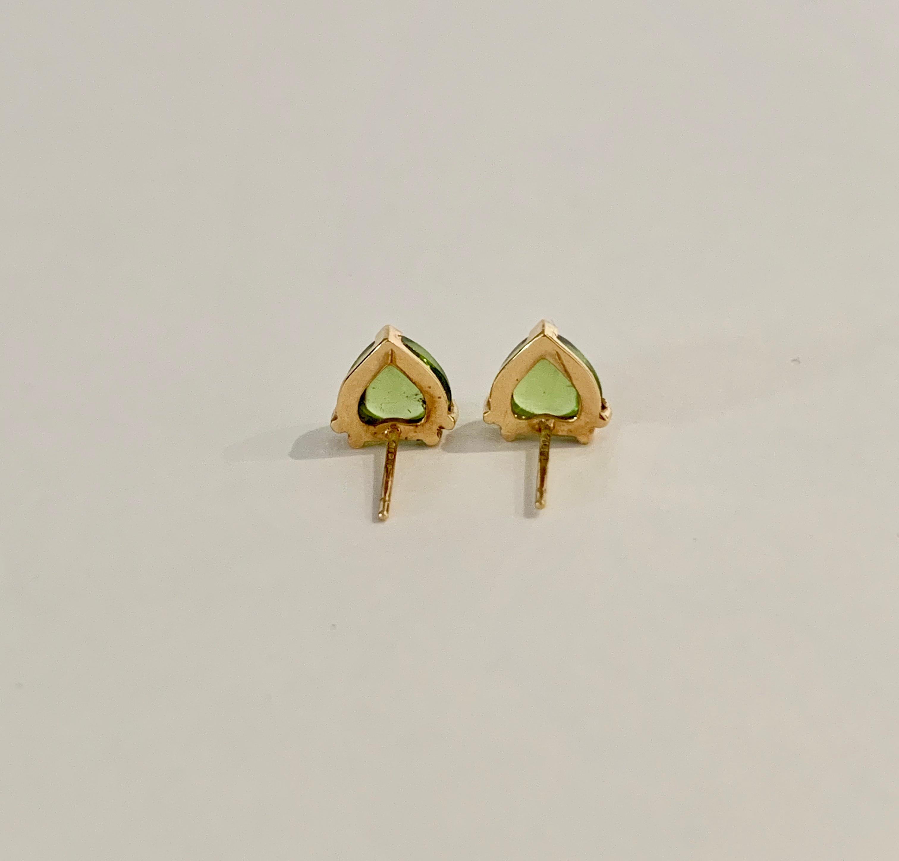 These very pretty Bespoke heart shaped Peridot* stud earrings have been designed with two sets of double claws and a rub over design at the tip.  A CAD was used to make this design especially for these heart shaped cabochon* stones,  also making the