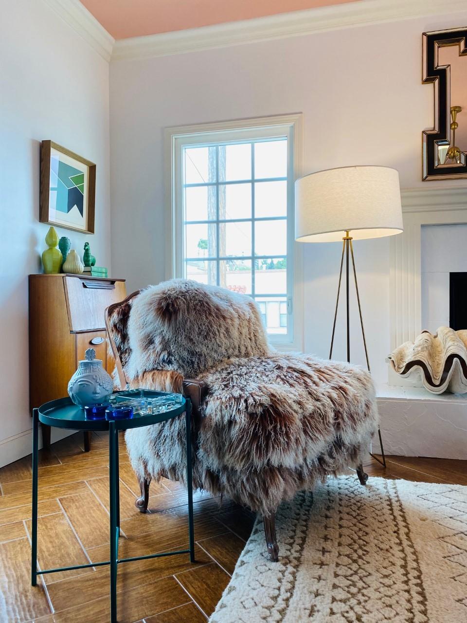 This one of a kind piece is a delicious fusion of form and function. The Auberge style frame in a weathered wood finish establishes a rustic-chic style. The shaggy mongolian sheep fur in neutral creams and reddish browns adds volume and lightness to