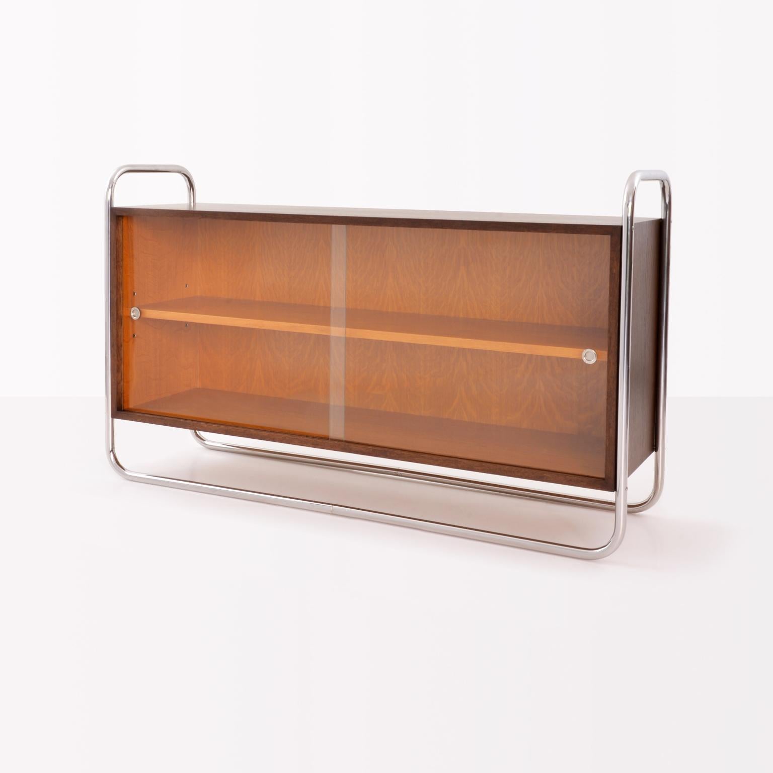 Librería baja de acero tubular Bauhaus de acero tubular niquelado, tablero de bloques chapado y paneles correderos de cristal. Personalizable, tiempo de producción c. 8 semanas.