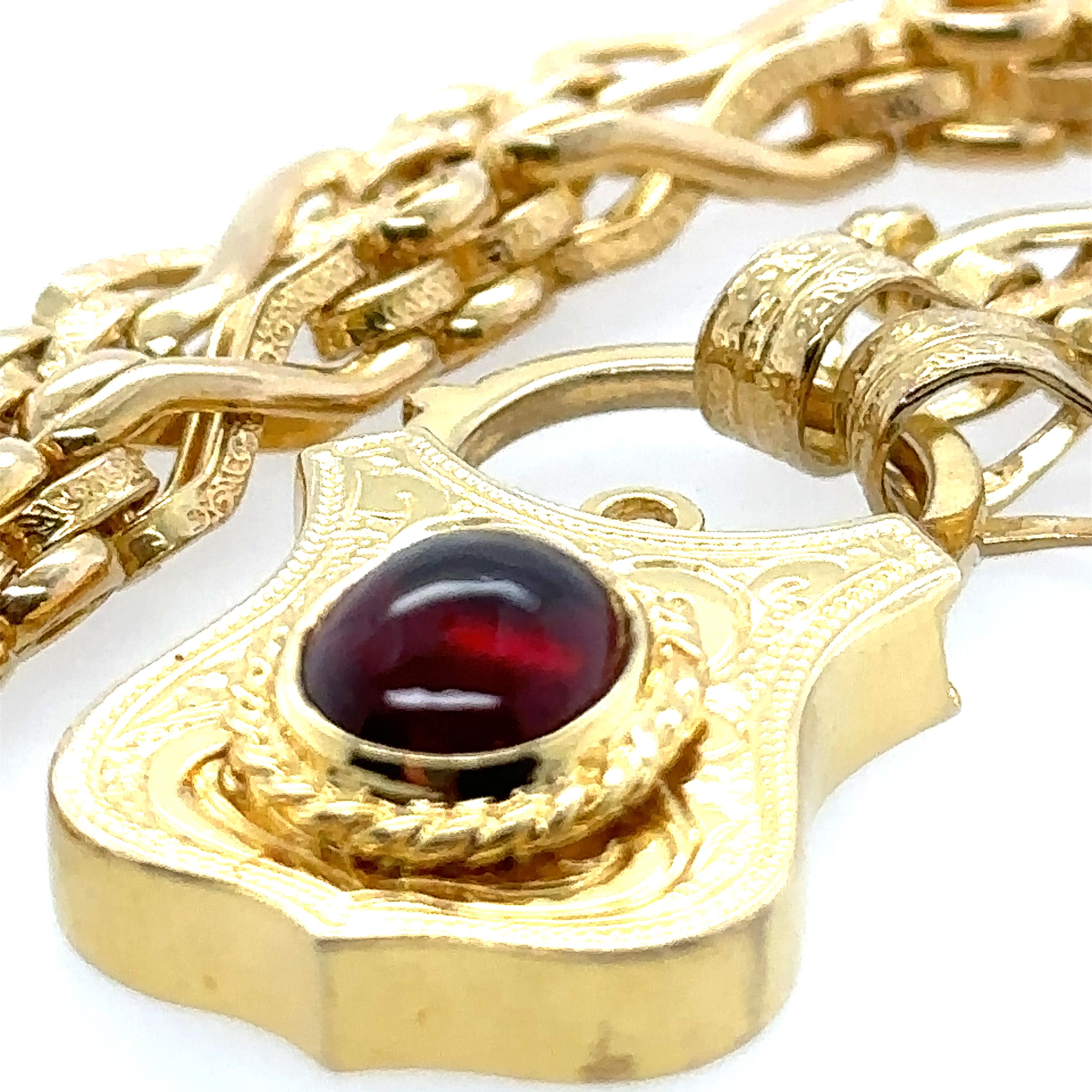 A 9ct Yellow Gold Riveted Patterned Link 45cm Necklace, with a 9ct yellow gold cabochon cut garnet padlock clasp. 

Metal: 9ct Yellow Gold
Carat: N/A
Colour: N/A
Clarity:  N/A
Cut: Cabochon Cut
Weight: 37.73 grams
Engravings/Markings: 375