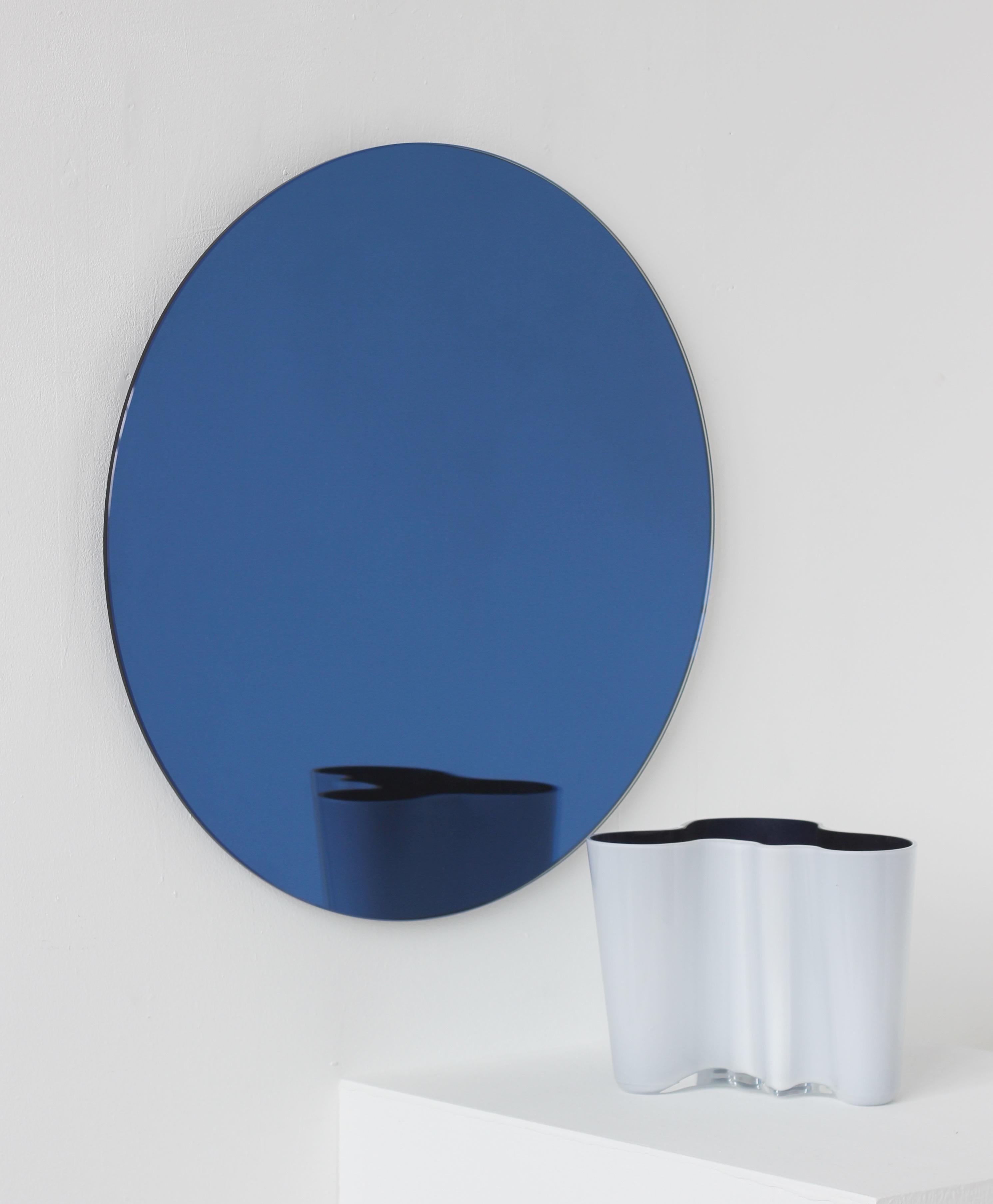 Charming and minimalist round frameless blue tinted Orbis™ mirror with a floating effect. Quality design that ensures the mirror sits perfectly parallel to the wall. Designed and made in London, UK.

Fitted with professional plates not visible once