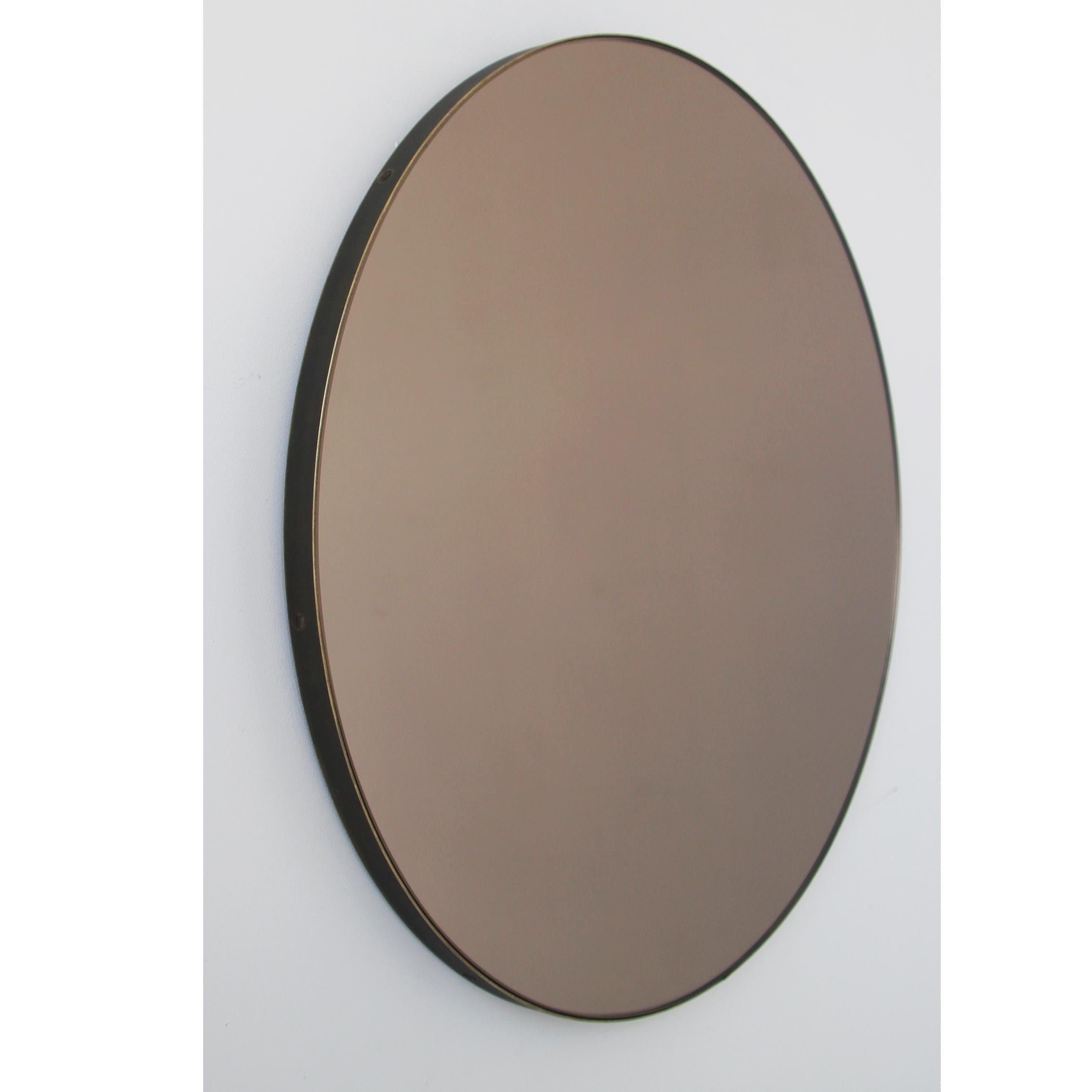 Contemporary bronze tinted round mirror with an elegant bronze patina brass frame. Designed and handcrafted in London, UK.

Medium, large and extra-large mirrors (60, 80 and 100cm) are fitted with an ingenious French cleat (split batten) system so
