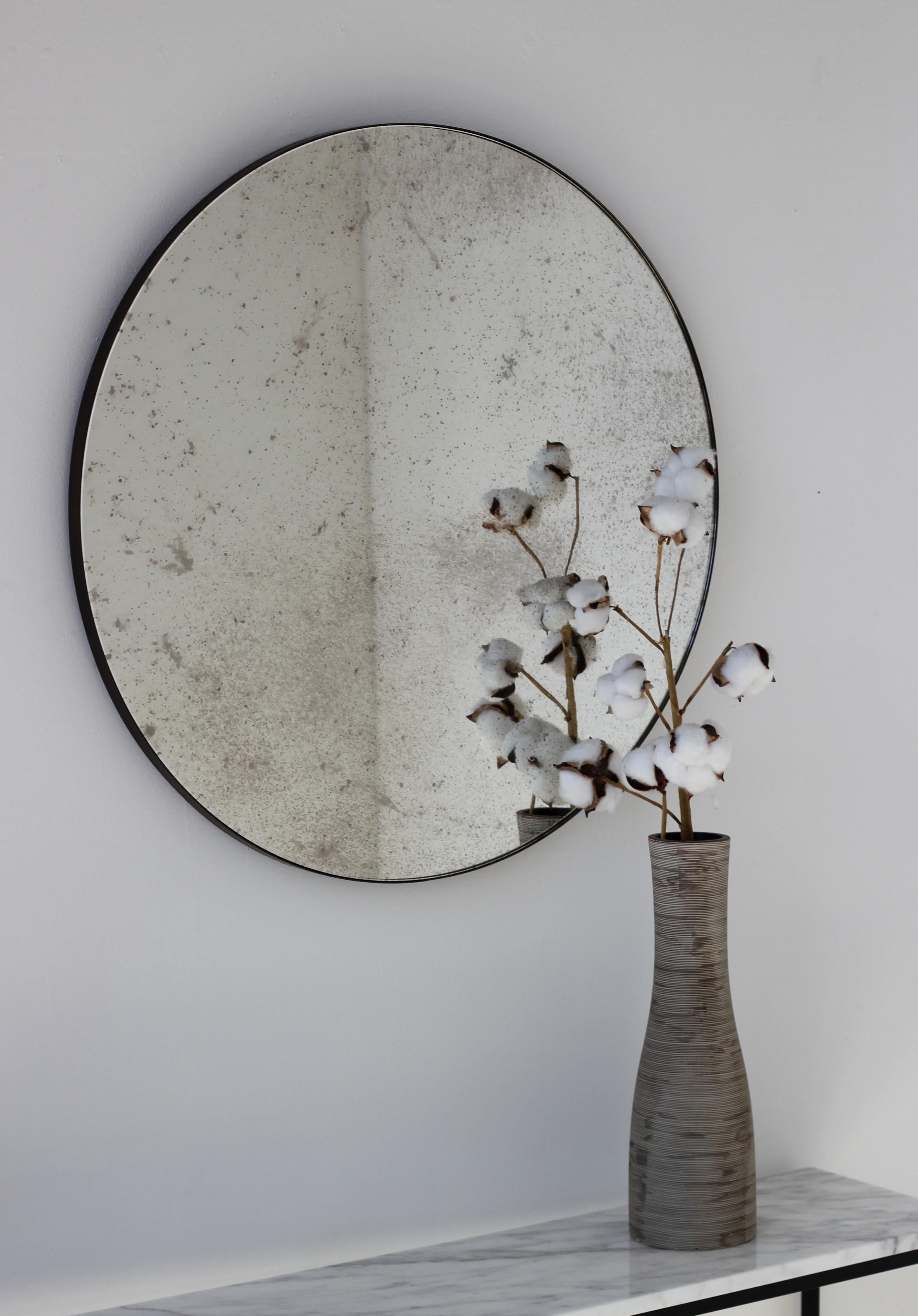 Delightful antiqued Orbis™ round mirror with a minimalist bronze patina brass frame. Designed and handcrafted in London, UK.

Medium, large and extra-large mirrors (60, 80 and 100cm) are fitted with an ingenious French cleat (split batten) system so