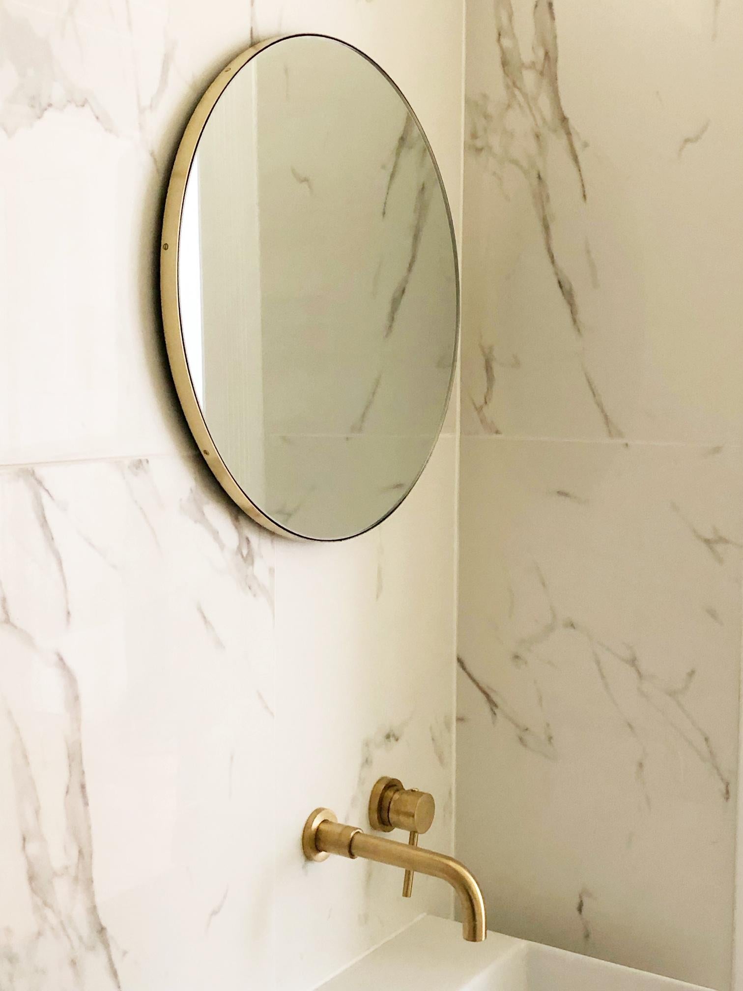 Miroir rond minimaliste Orbis™ doté d'un élégant cadre en laiton massif brossé. Les détails et la finition, y compris les vis en laiton visibles, soulignent l'aspect artisanal et la qualité du miroir, véritable signature de notre marque. Conçu et