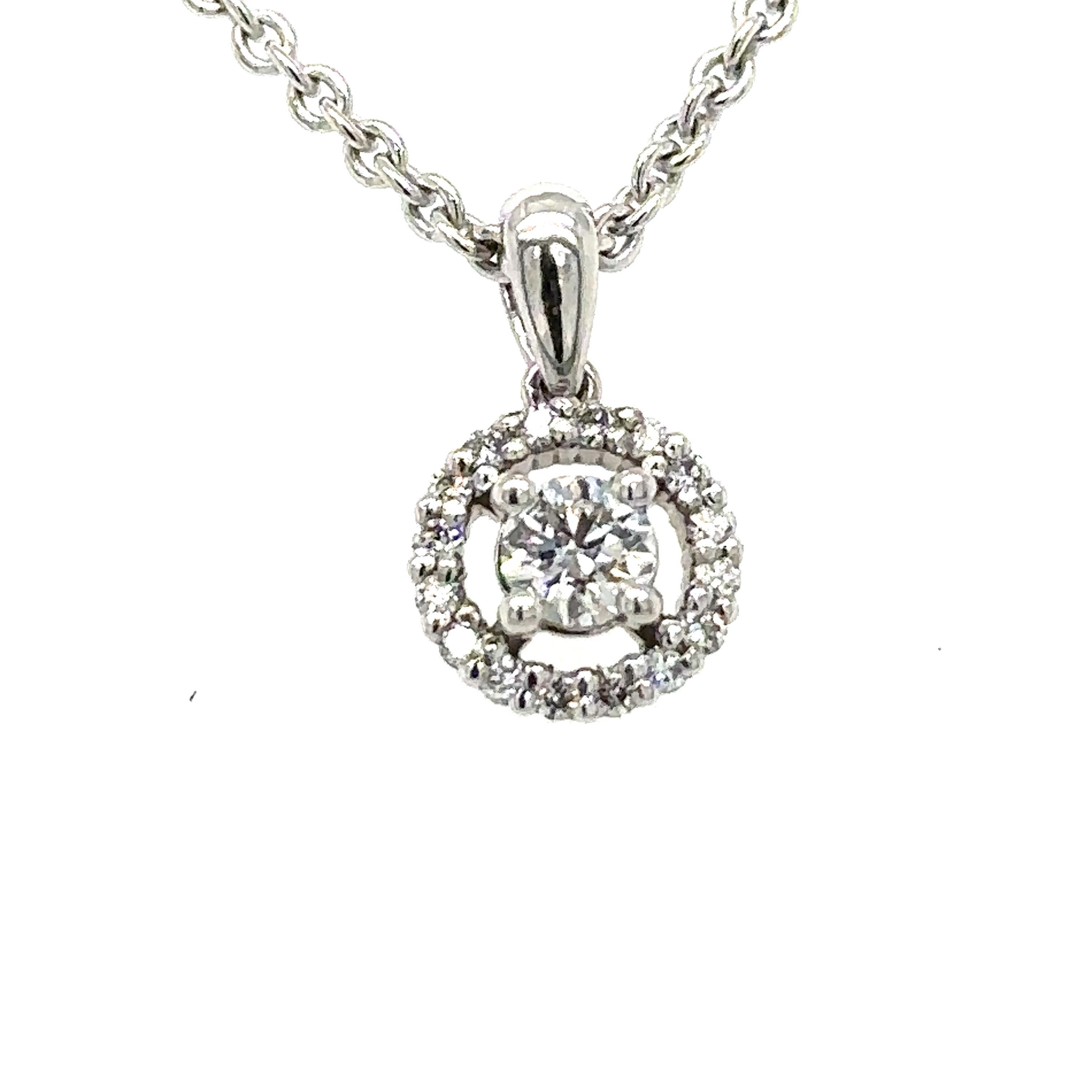 A Diamond Round Cluster Necklace, with a round brilliant cut diamond within a border of 16 round brilliant cut diamonds on a 9ct white gold trace link neck chain.

Diamonds 1 = 0.18ct (estimated), F/VS

16 = 0.13ct (estimated), F/VS
Metal: 9ct White