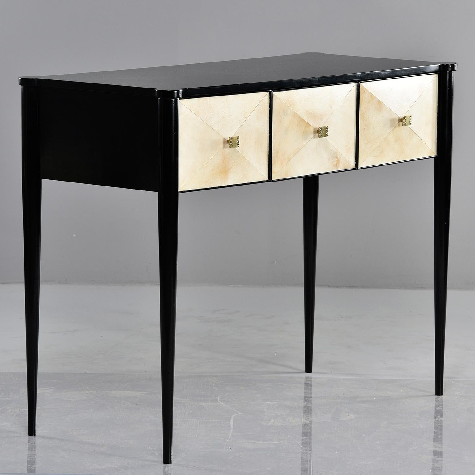 Custom created by English cabinet maker, this console has an ebonized wood frame with tapered legs and three functional drawers with vellum covered fronts. Brass hardware.