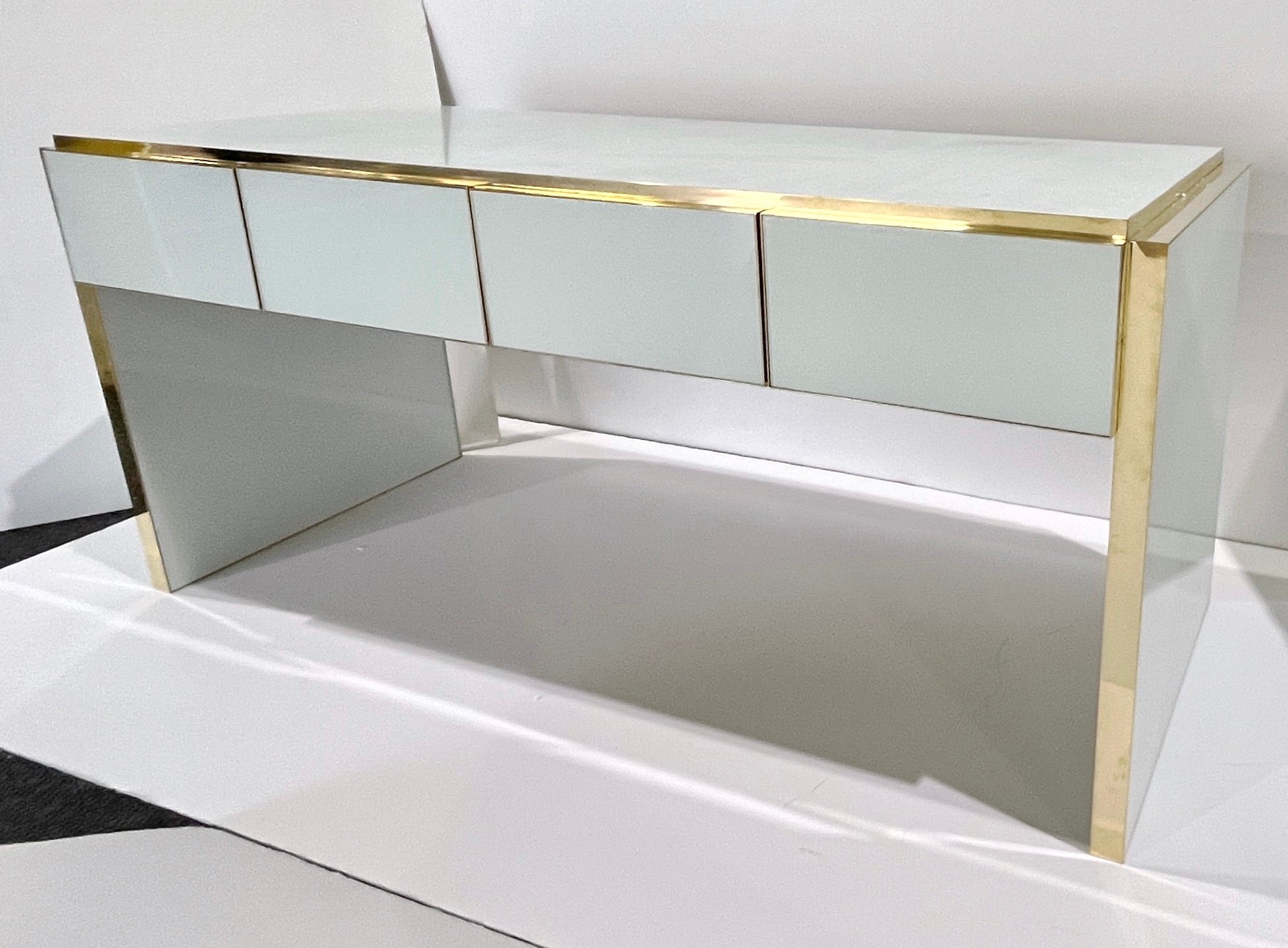 Bureau / console moderne contemporain personnalisable à 4 tiroirs entièrement fabriqué à la main en Italie, avec un design Art-Deco minimaliste, le pourtour décoré de verre d'art dans une couleur blanche minimaliste saisissante. Ce bureau, élevé sur