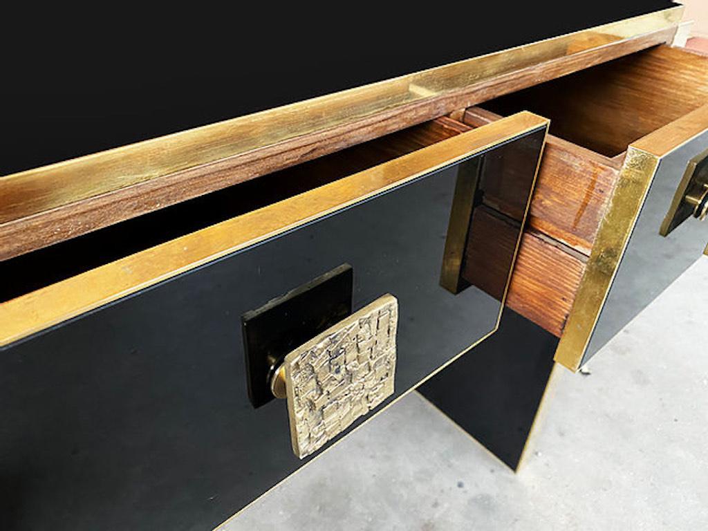 Contemporary Bespoke customizable 4-drawer modern console table, entirely handcrafted in Italy, with elegant Hollywood Regency style, the dramatic surround decorated with art glass in a striking high-shine black like lacquer, highlighted with cast