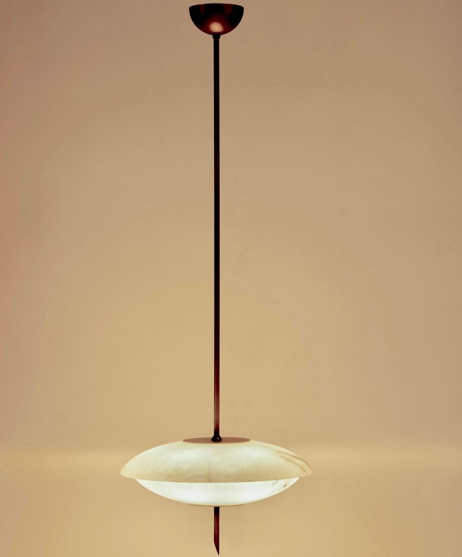 The Cosmos chandelier is inspired by the sleek design aesthetics of the 1950s, recalling the pioneering spirit of the Space Age. Its convex alabaster plates softly diffuse warm light, creating a welcoming atmosphere in any space. The brushed brass