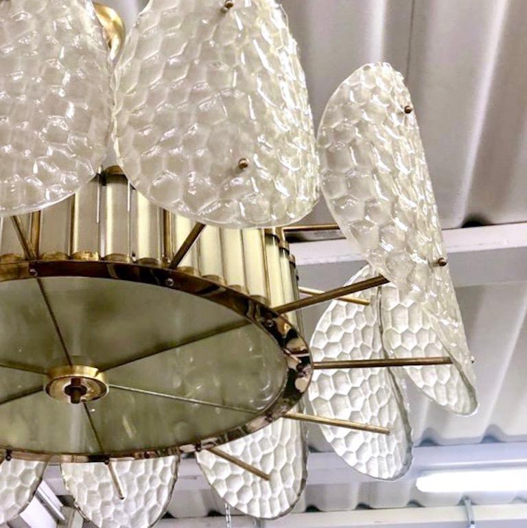 A contemporary custom organic modern flushmount, entirely handcrafted in Italy, with a handmade brass double frame with Art Deco flair and Hollywood glam. The exterior is formed by nature-inspired oval convex elements resembling sea turtle backs in