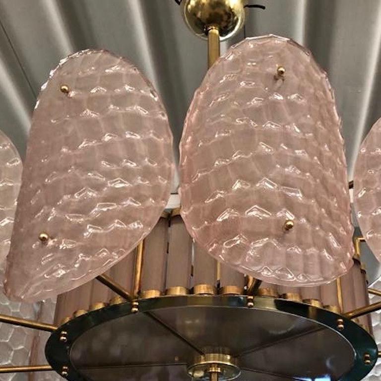 A contemporary custom organic modern chandelier, entirely handcrafted in Italy, with a handmade brass double frame with Art Deco flair.
The exterior is formed by nature-inspired oval convex elements resembling sea turtle backs in blown textured