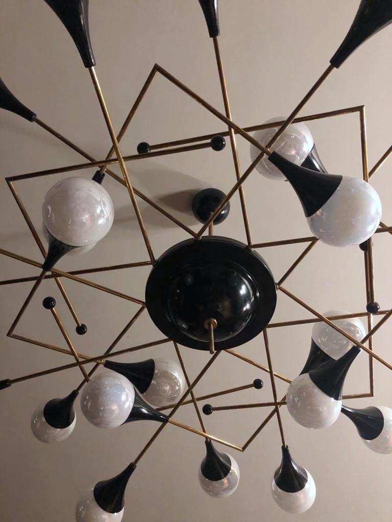 Stilnovo Style contemporary 24-light flushmounts / chandelier in a Mid-Century Modern design, the very interesting light airy structure constructed with diamond shaped squares created with brass rods, some ending with black lacquered balls, supports