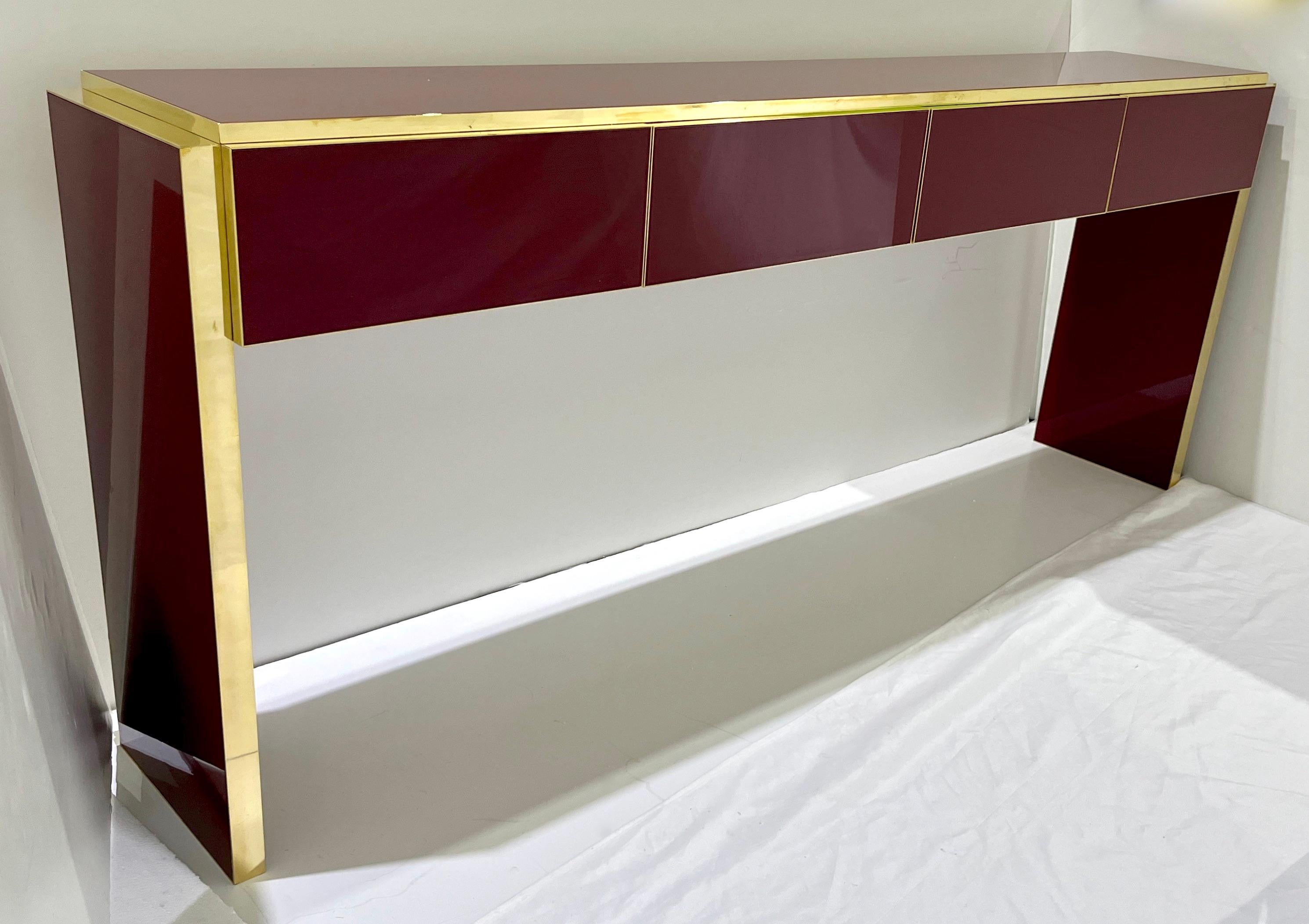 Contemporary Bespoke customizable 4-drawer long modern console / sideboard, entirely Hand Made in Italy, with a minimalist Art Deco Design, the surround is decorated with art glass in a striking wine burgundy color. This console of a modern sleek
