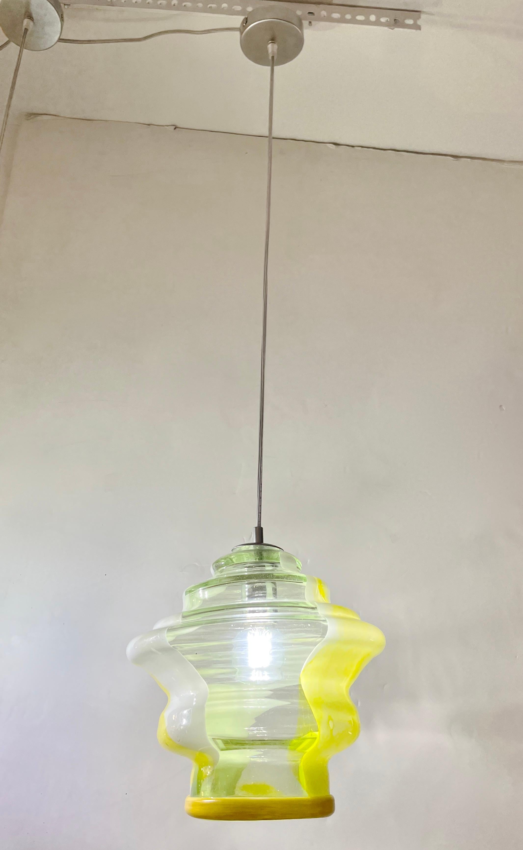 Fun and elegant Italian contemporary custom-made pendant chandelier, of organic modern design, entirely handcrafted with adjustable height, consisting of a sexy multi level stepped circular shade in translucent lemon yellow blown Murano glass