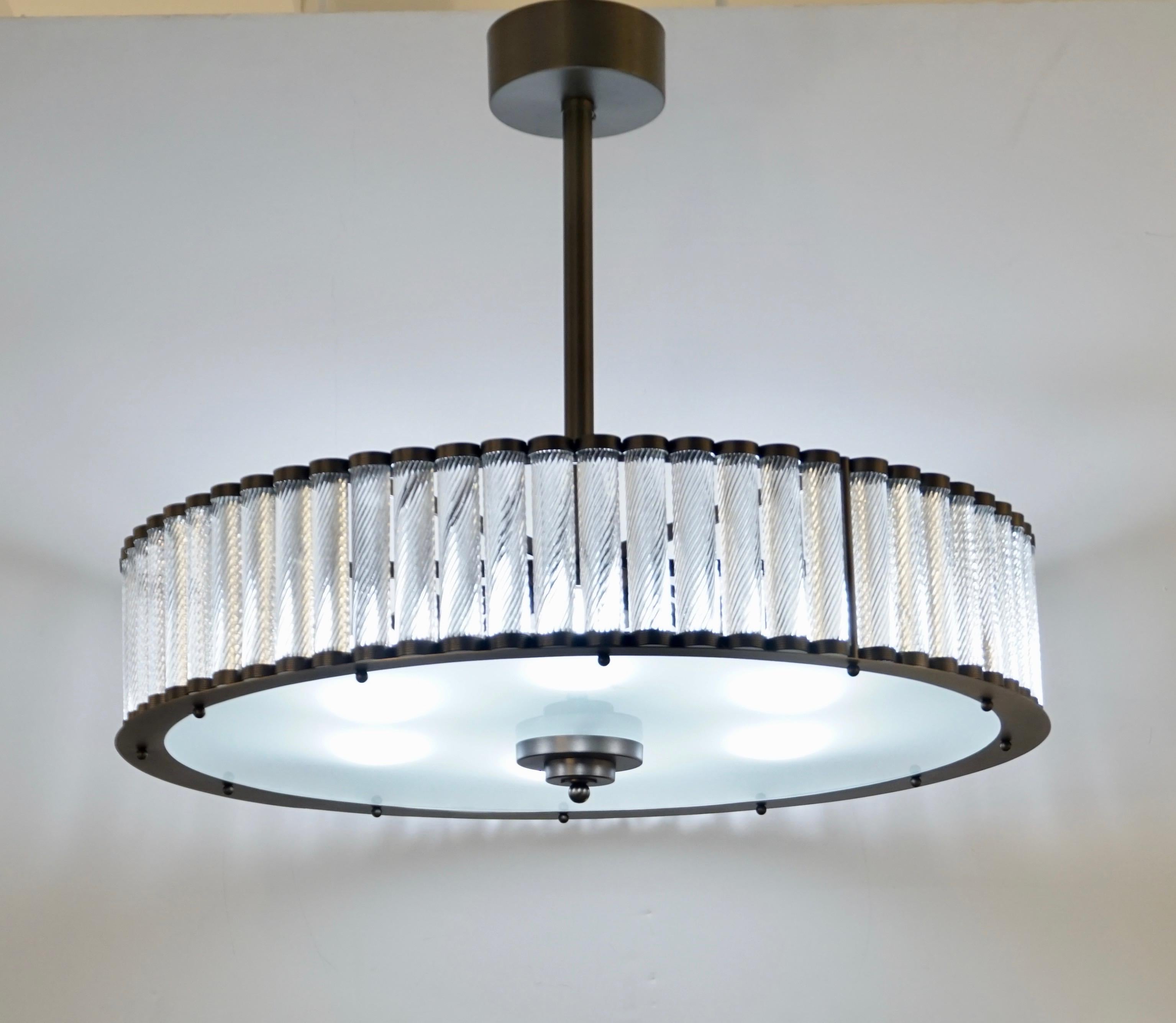 Contemporary Italian Art Deco design customizable round chandelier/pendant of drum shape, entirely handcrafted, with a dark silver steel gunmetal finish. The nicely scalloped airy structure supports crystal clear Murano glass rods, each individually