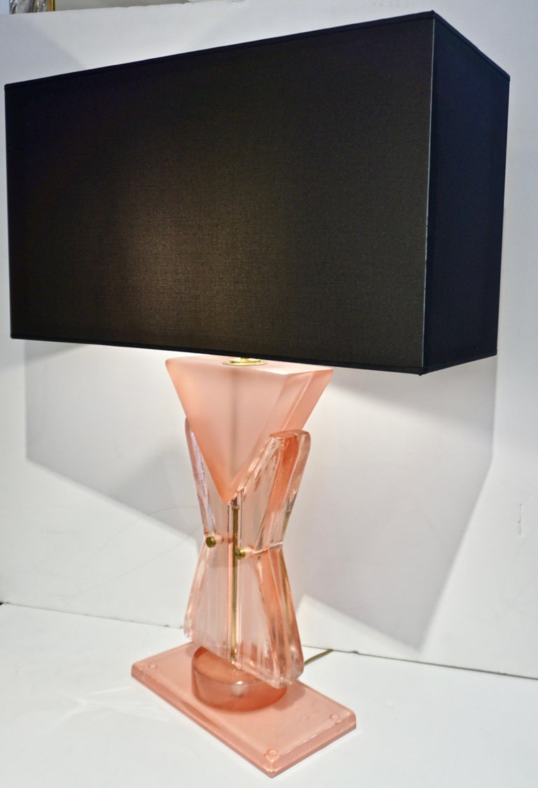 A fun modernist table / desk lamp, a contemporary organic creation entirely hand made in Italy, the geometric shape inspired by a fashion tailored suit design, the waisted middle part in transparent pink crystal double glass frosted with stripes,