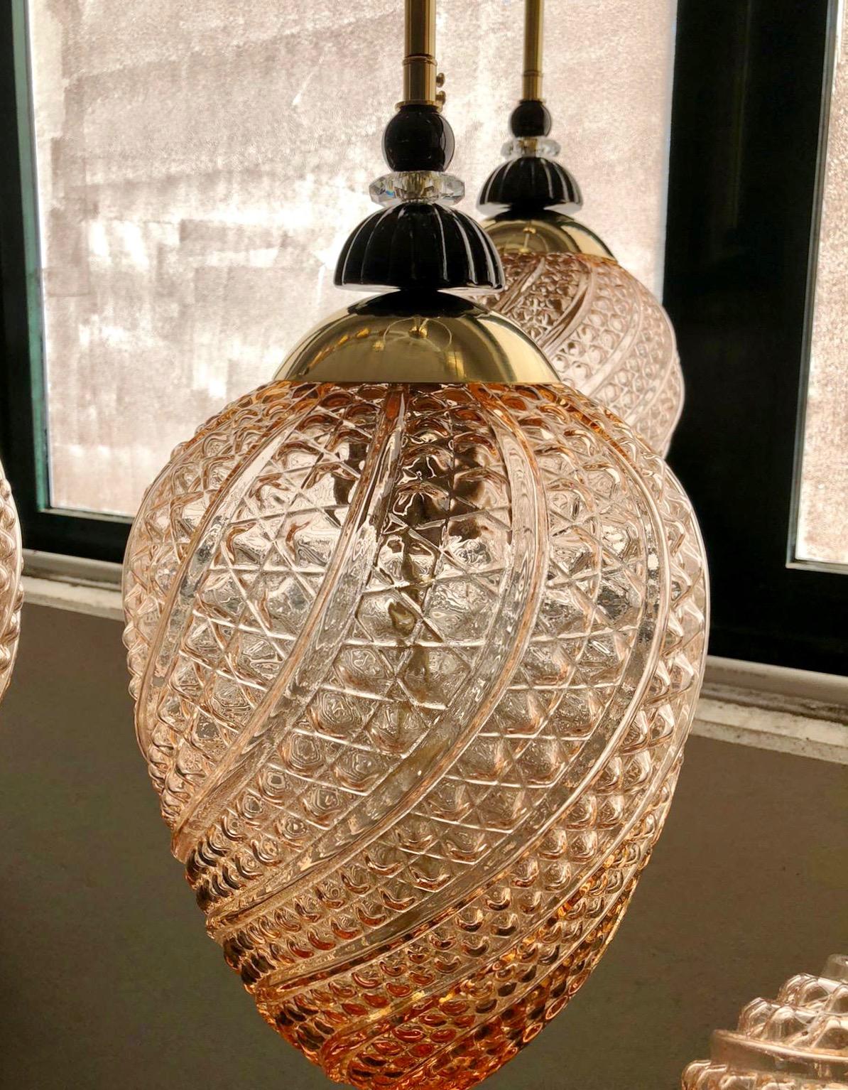 Contemporary orientalist style custom pendants / chandeliers, a modern Venetian geometric series with brass hardware, entirely handcrafted in Italy, the organic globes in egg, ovoid, and sphere shapes in an innovative blown textured Murano glass