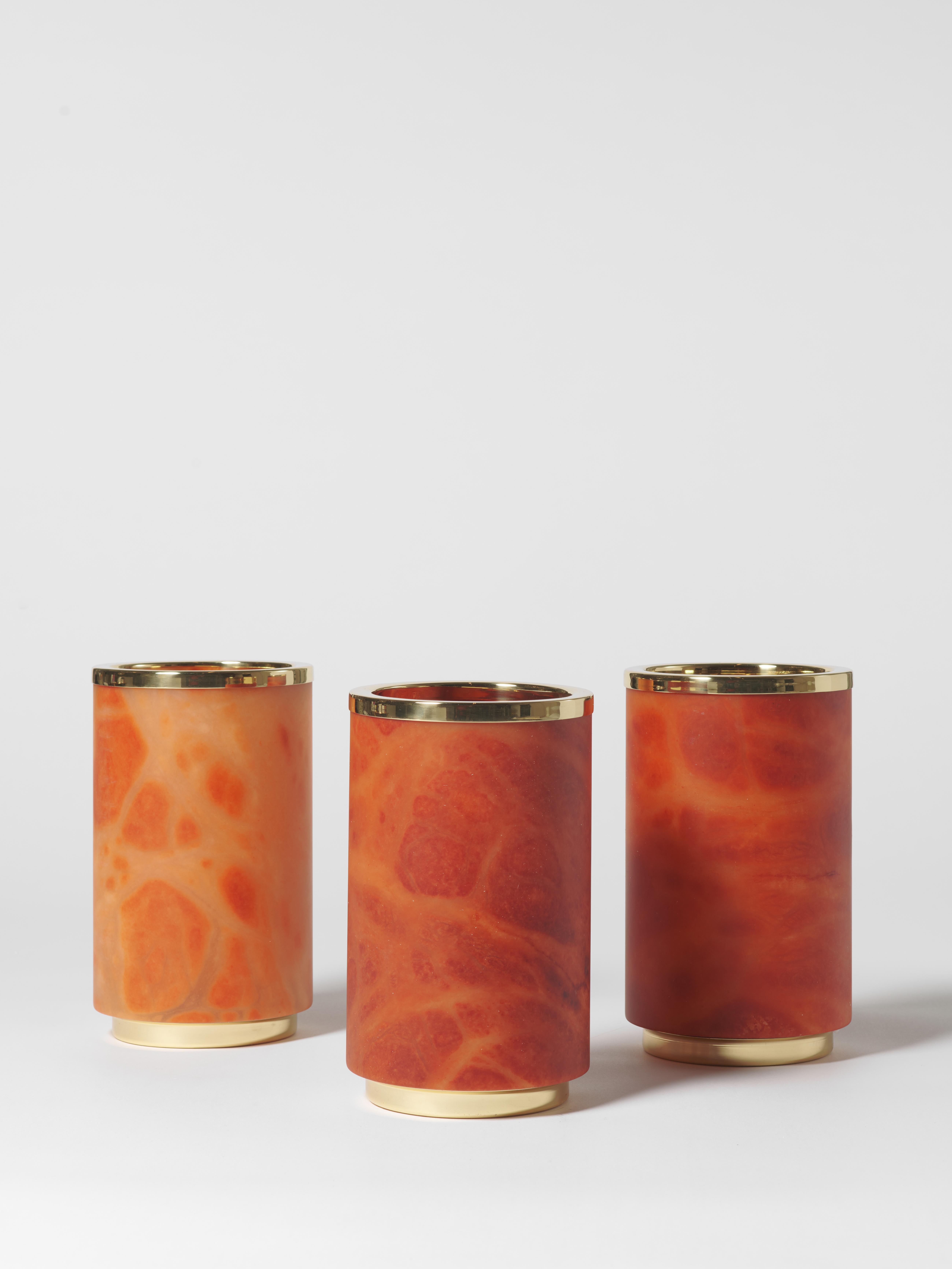 Este exquisito jarrón combina la belleza atemporal del alabastro anaranjado con el toque refinado del latón pulido. Su forma cilíndrica realza su elegancia minimalista, convirtiéndolo en un sofisticado complemento para cualquier interior. El veteado
