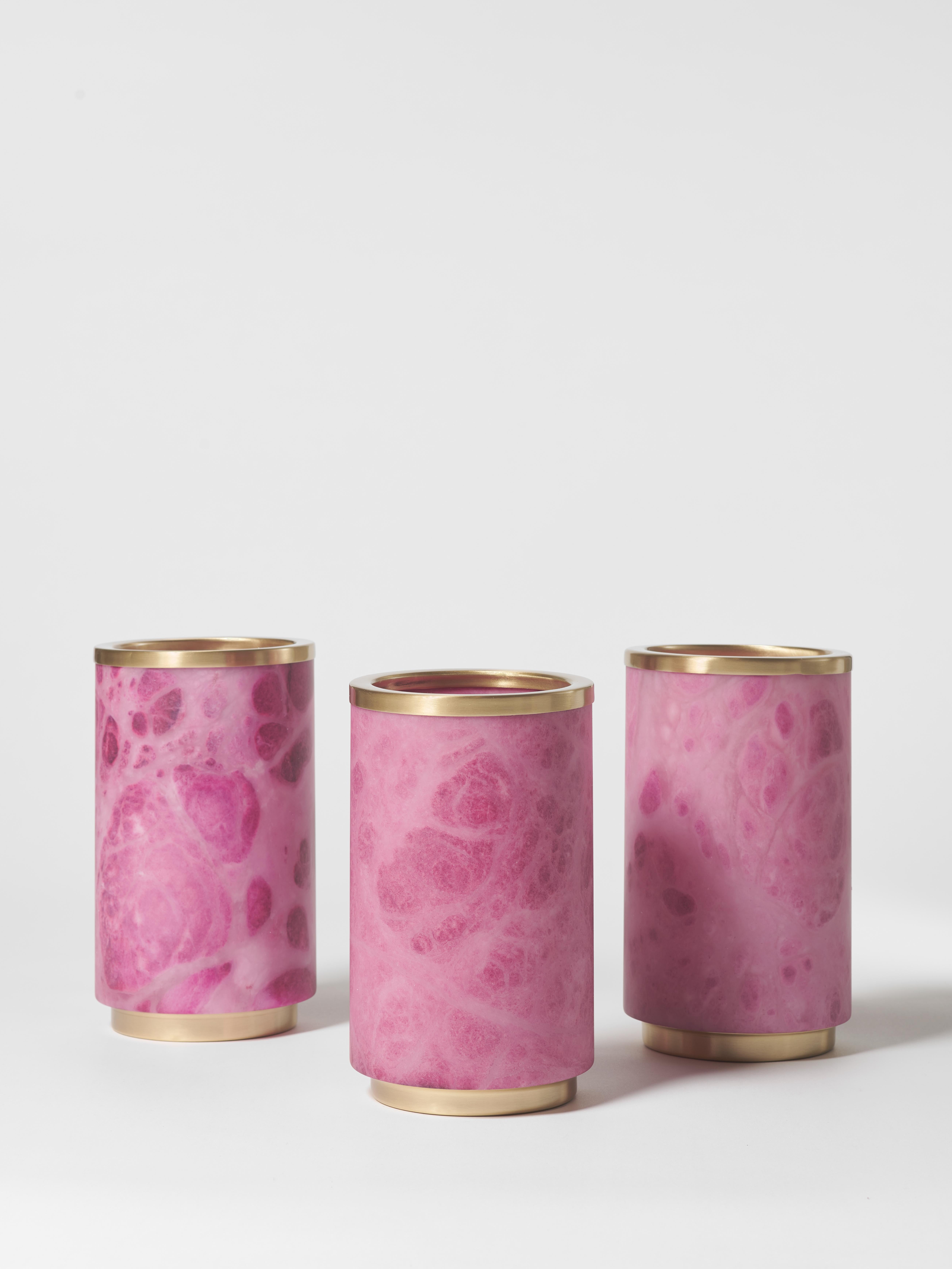 This exquisite vase combines the timeless beauty of pink alabaster with the refined touch of satin brass. Its cylindrical shape enhances its minimalist elegance, making it a sophisticated addition to any interior. The natural veining of the
