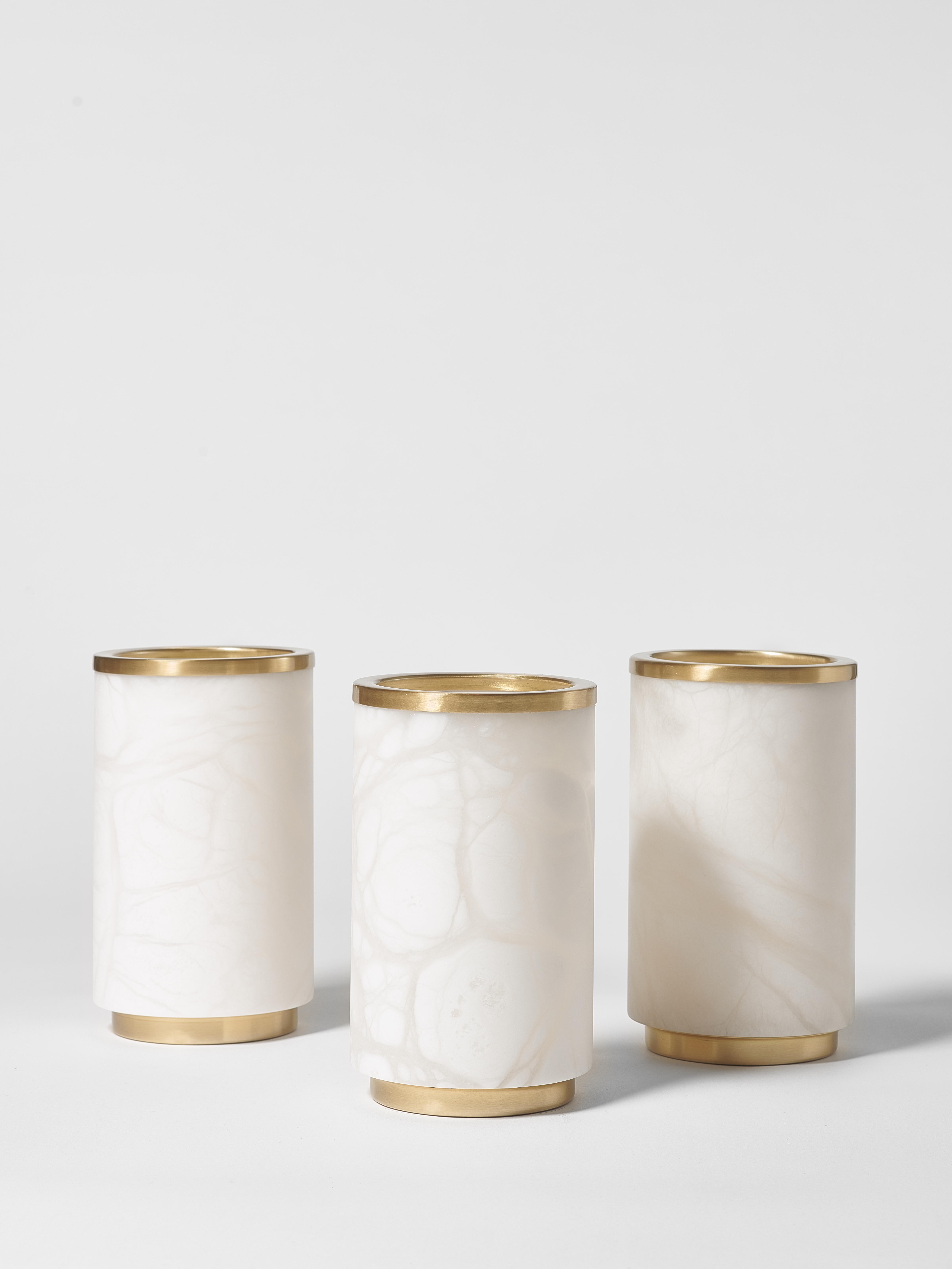 This exquisite vase combines the timeless beauty of white alabaster with the refined touch of satin brass. Its cylindrical shape enhances its minimalist elegance, making it a sophisticated addition to any interior. The natural veining of the