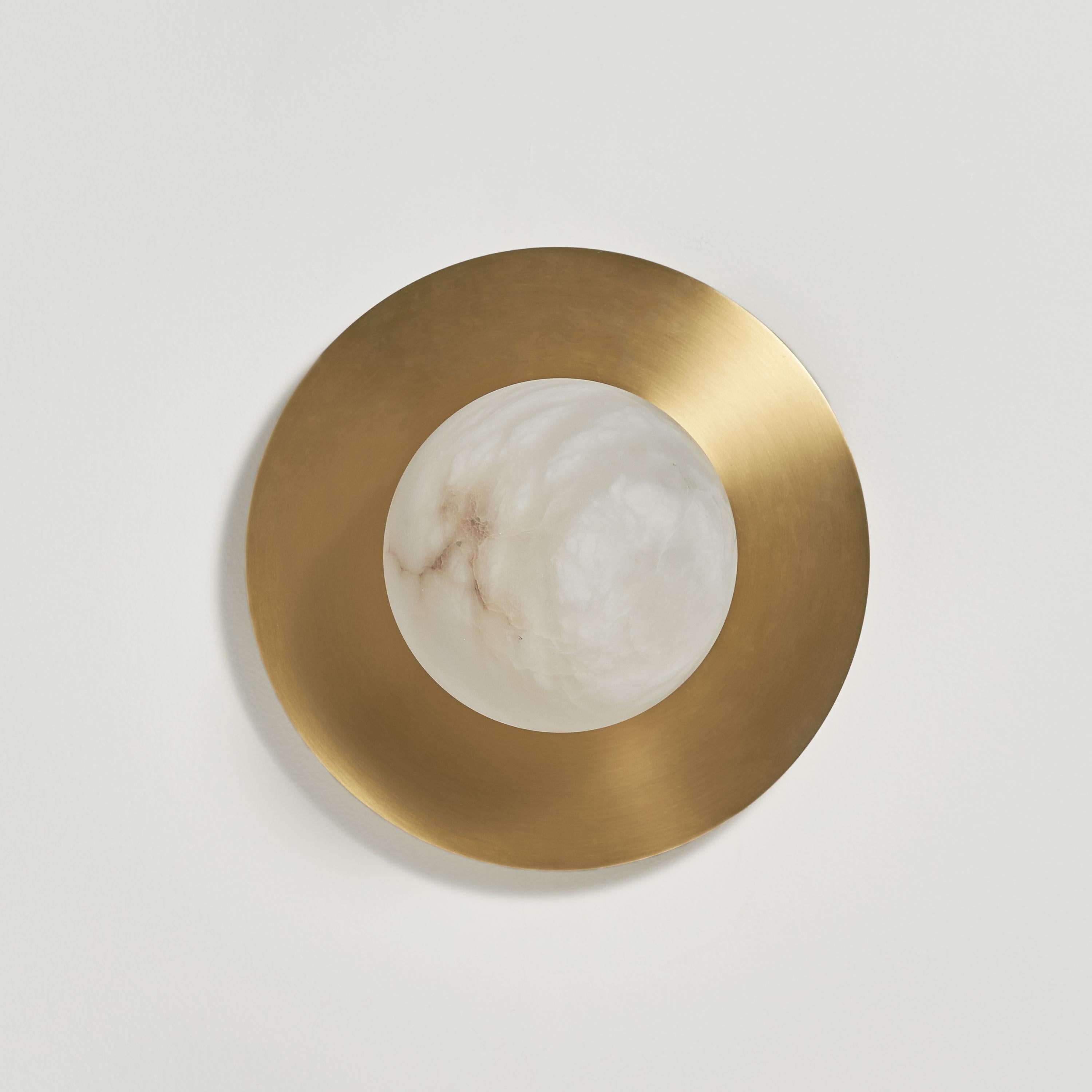 The natural properties of alabaster as a diffuser: warm color and the texture of its veins that are always different from each other, recalling the magic atmosphere of full moon nights. The brass disk completes the shape, enhancing the light emitted