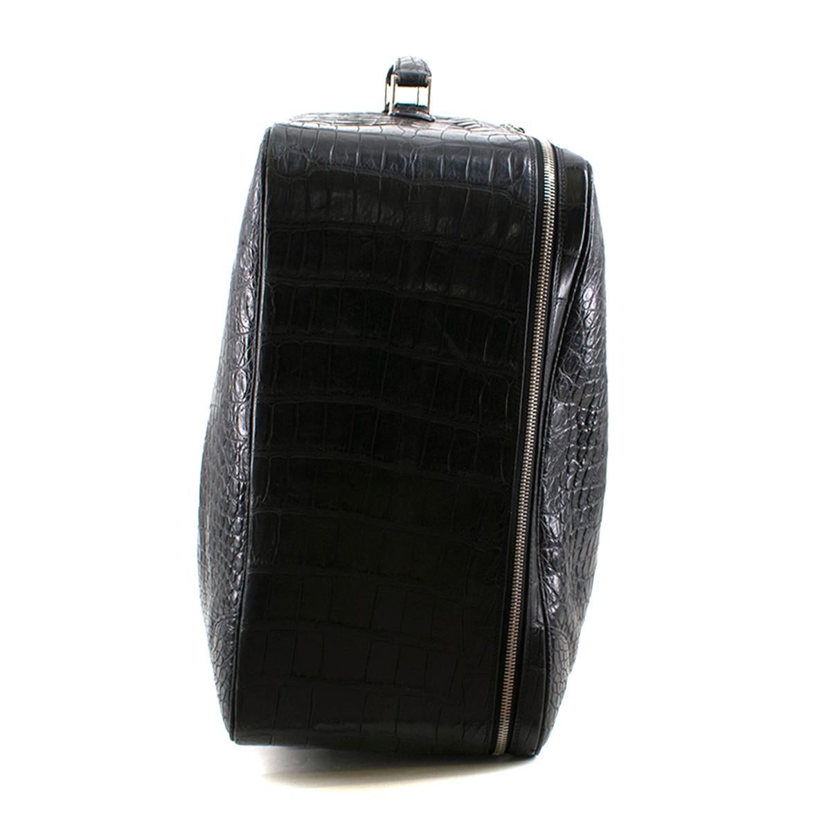 Bespoke large black crocodile leather suitcase

- Black, matte crocodile leather 
- Top handle, comes with a protective handle cover 
- Silver-tone metal hardware and protective plastic feet 
- Zip-around closure 
- Internal zip-fastening