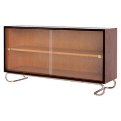 Librería baja a medida, madera teñida, paneles deslizantes de cristal y base de acero tubular