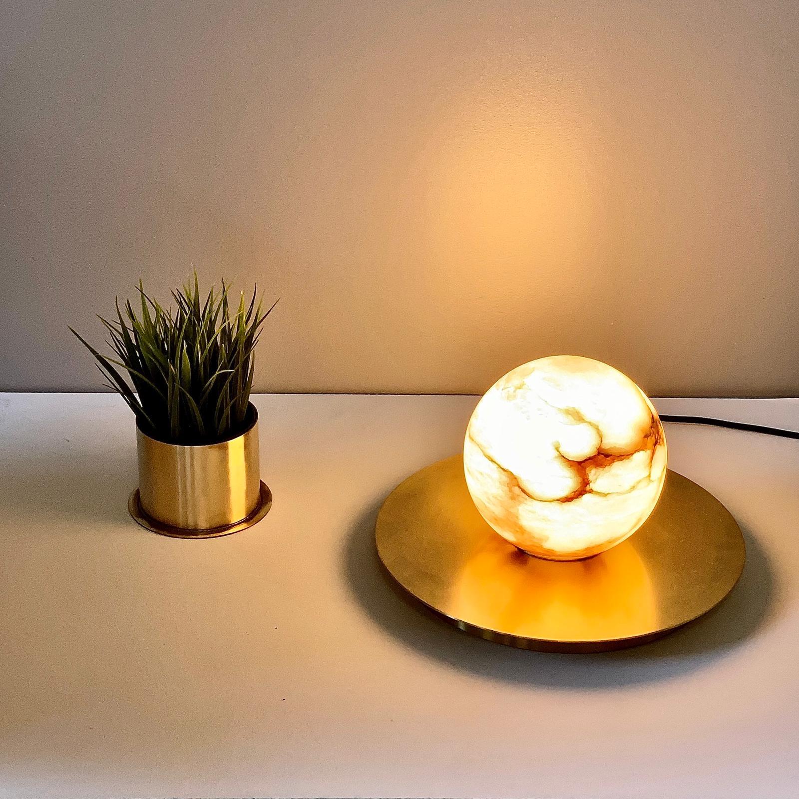 Cosulich Interiors in collaboration with Matlight Studio, this organic table lamp, part of the Alabaster Moon Collection, entirely handmade in Italy, emphasizes the properties of alabaster as a diffuser, with its warm color and texture of its amber