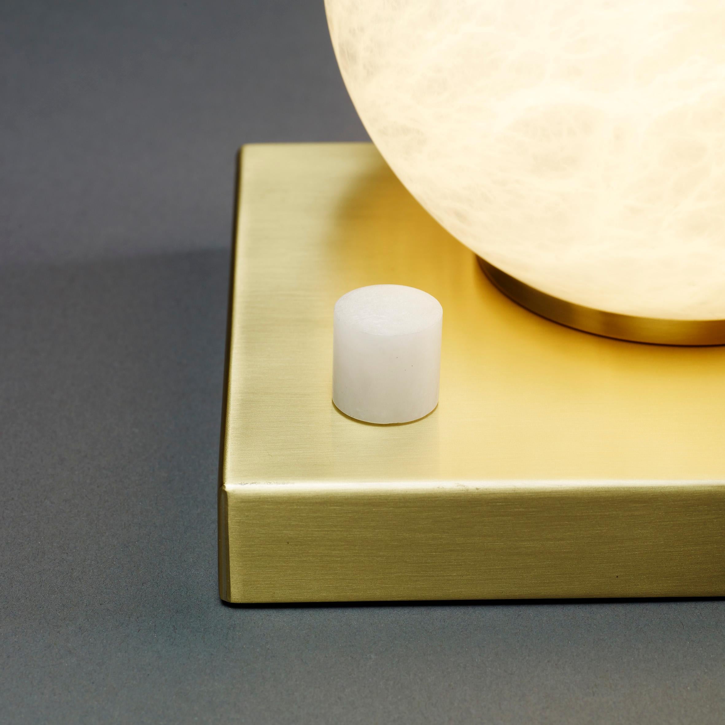 Cosulich Interiors in collaboration with Matlight Studio, this organic dimmable table lamp with square base, part of the Alabaster Moon Collection, entirely handmade in Italy, emphasizes the properties of alabaster as a diffuser, with its warm color