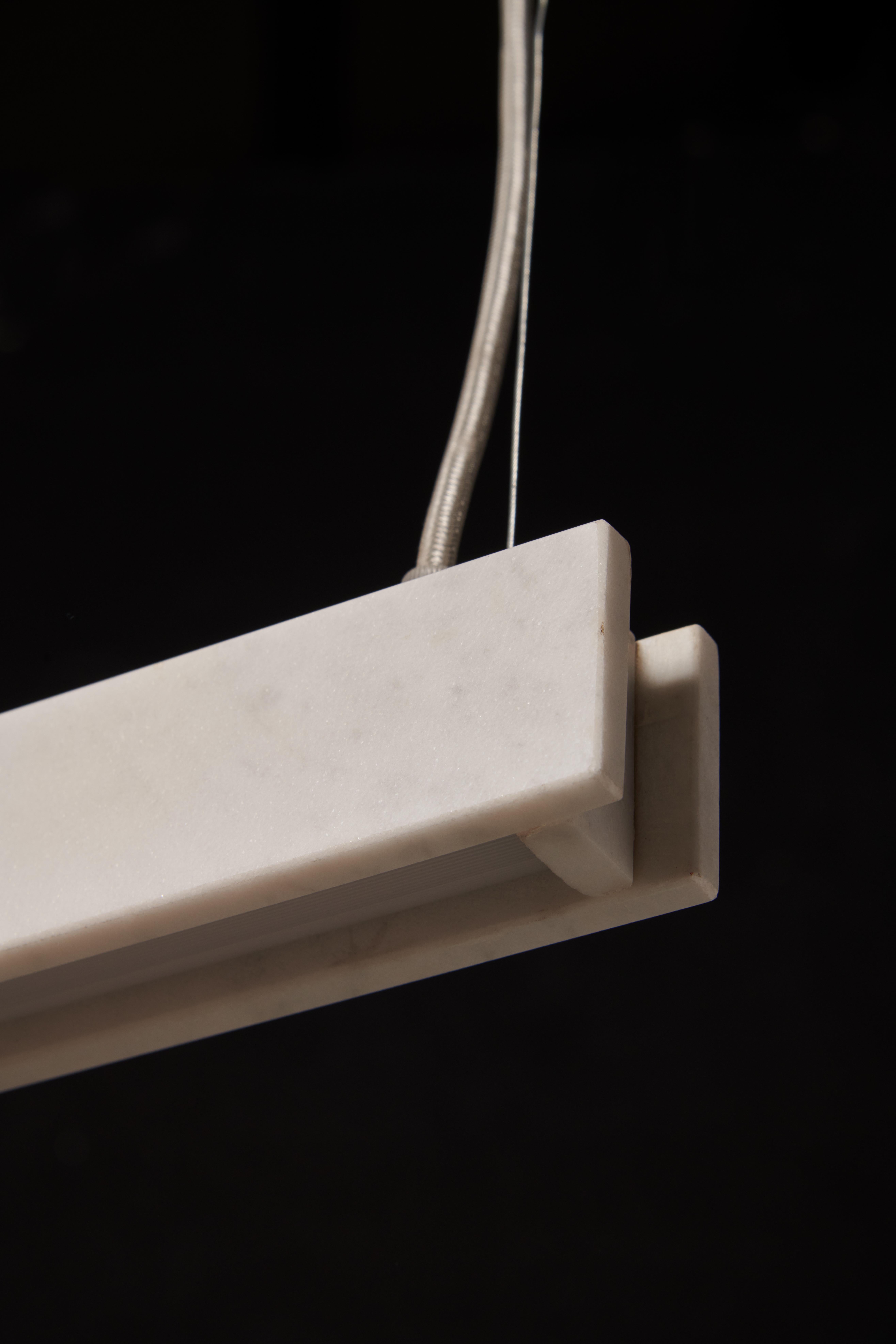 Il lampadario Profile H è un apparecchio unico che combina l'eleganza del marmo di Carrara con potenti capacità di illuminazione. È stato accuratamente progettato per fornire sia un'illuminazione indiretta, diretta verso il soffitto, sia