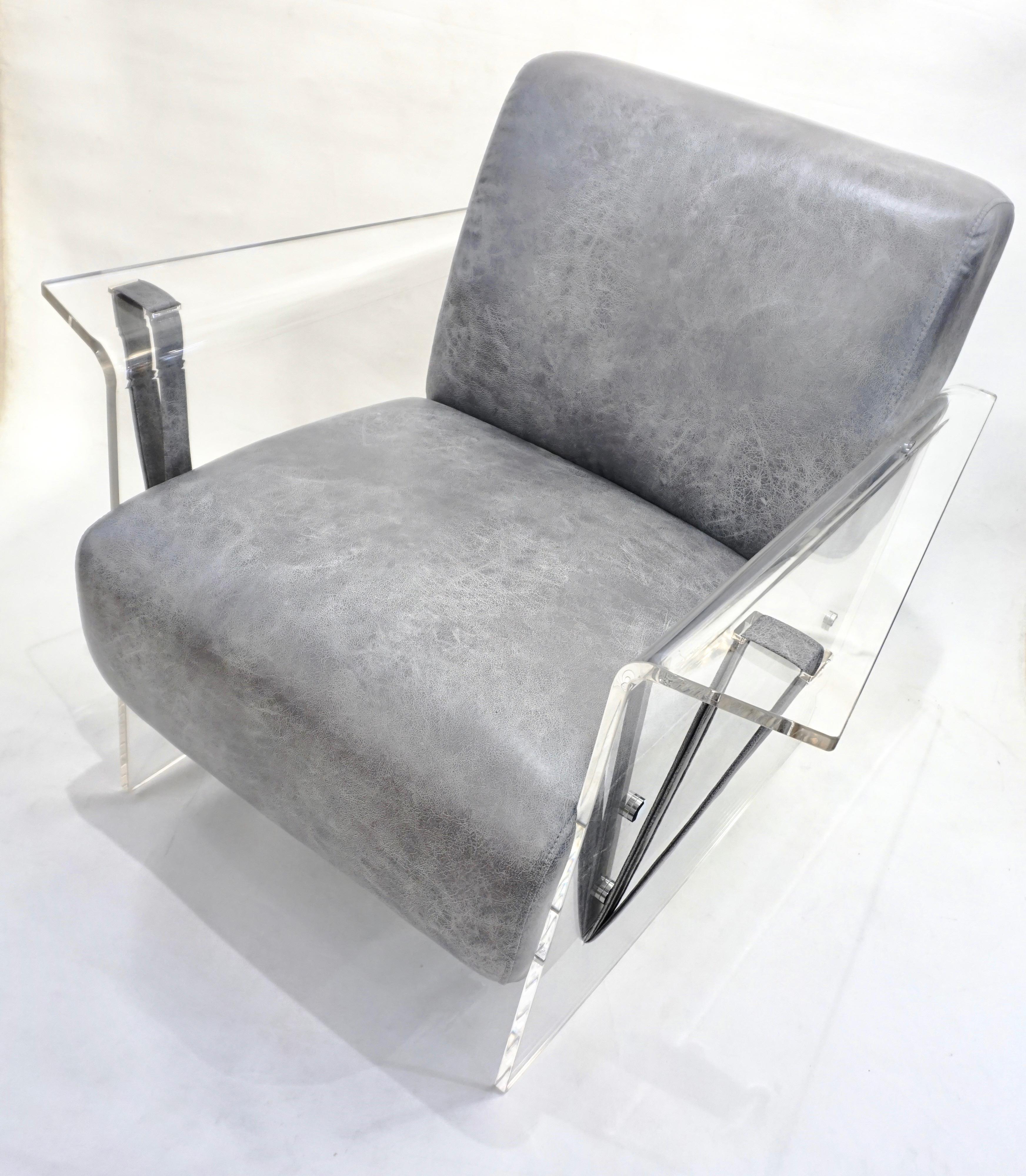 A very interesting contemporary loft armchair of modern sleek organic design enclosed in Minimalist upright seamless Lucite supports with chrome bolts and reversed armrest in a continuous line, accented on each side with a simple belt, ingeniously