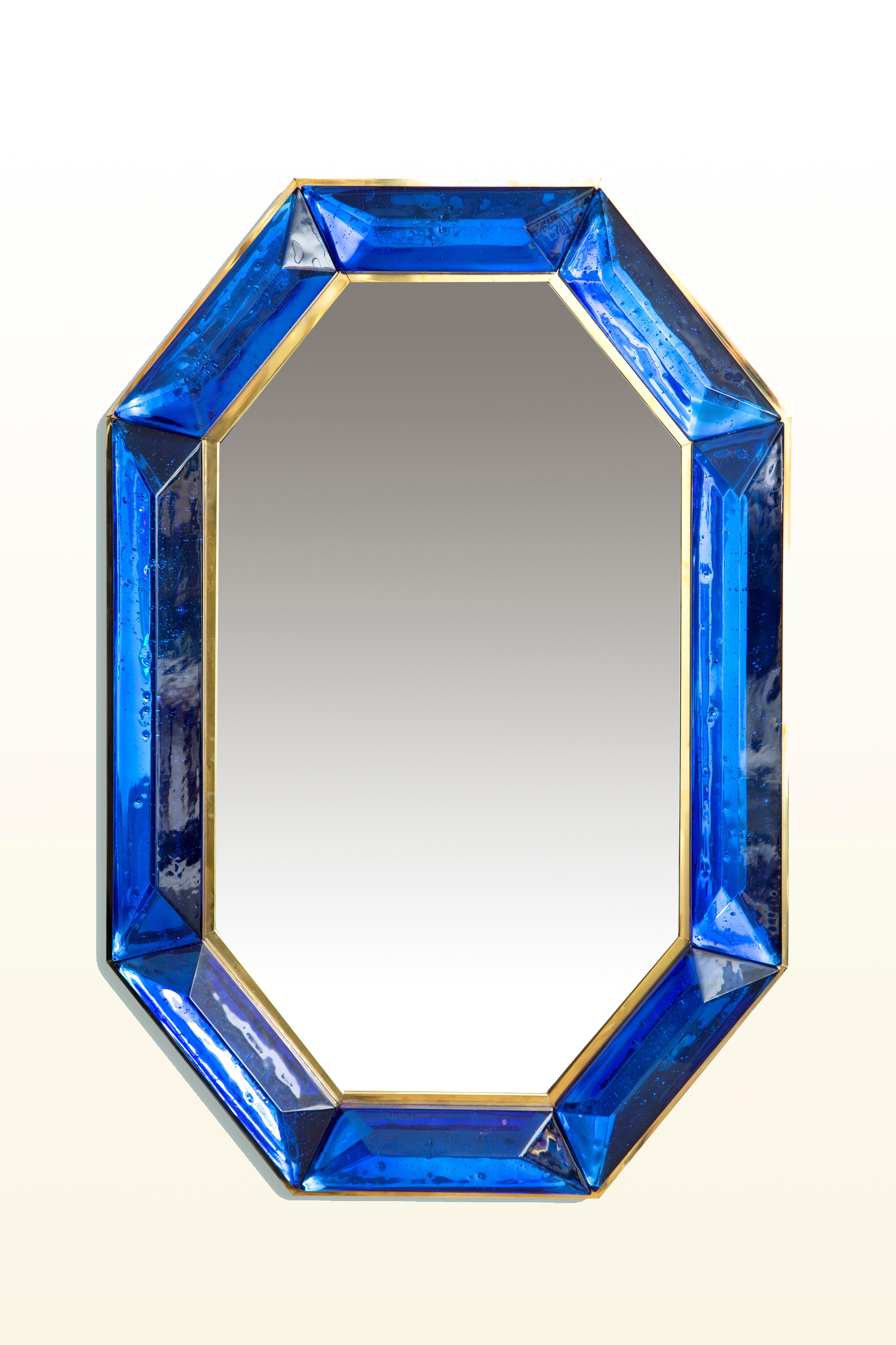 Bespoke octagon cobalt blue Murano glass mirror, in stock
 Vivid and intense cobalt blue glass block with naturally occurring air inclusions throughout 
 Highly polished faceted pattern
 Brass gallery all around
 Each mirror is a unique luxury