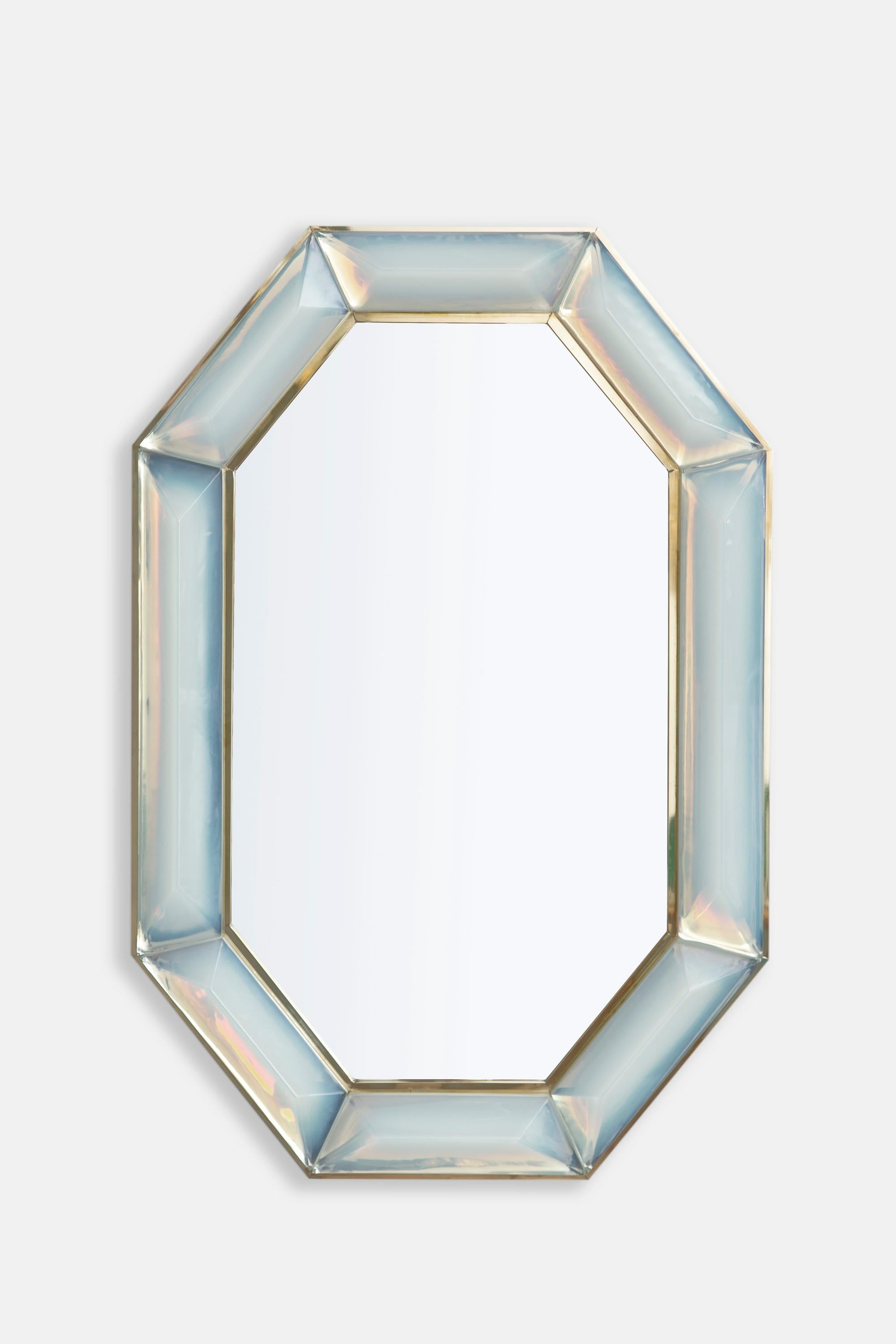 Bespoke octagonal iridescent opaline Murano glass mirror, in stock.
Vivid and intense iridescent opaline glass block with naturally occurring air inclusions throughout.
Highly polished faceted pattern.
Brass gallery all around.
Each mirror is a