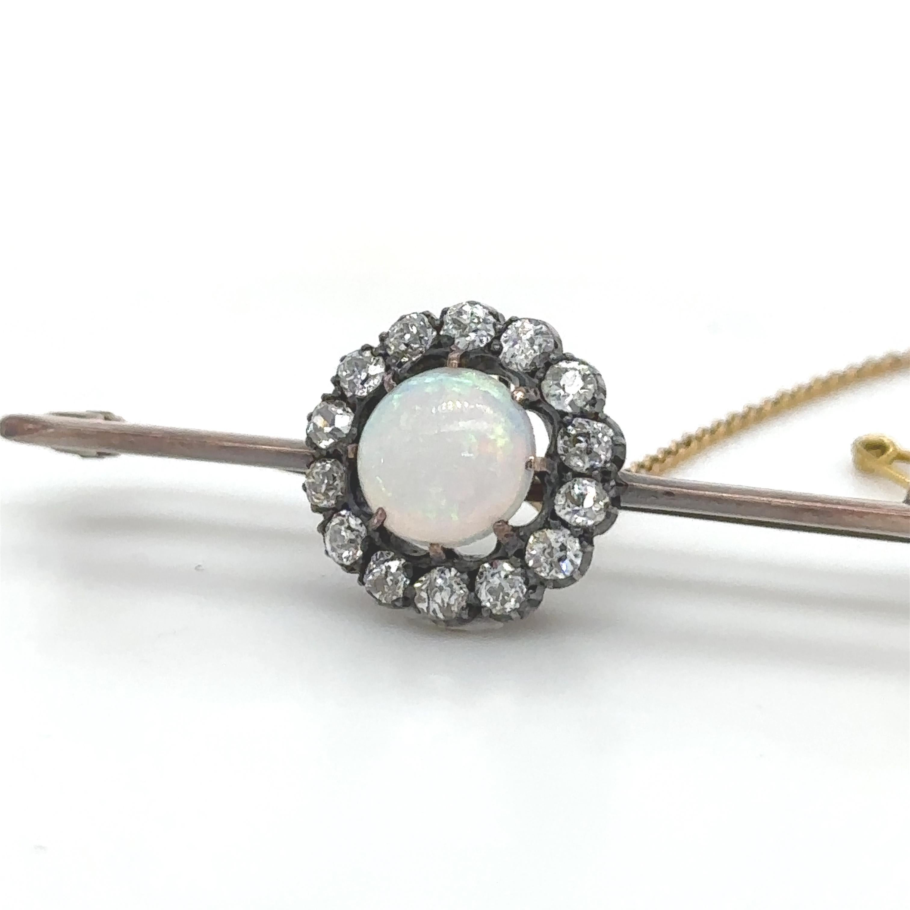 Broche en forma de racimo redondo de ópalo y diamantes, con un ópalo redondo de cristal blanco macizo dentro de un borde de 14 diamantes talla antigua engastados en plata y oro rosa de 9 ct.

Ópalo 1,00 ct (estimado), 8 mm redondo, 2,5 mm de