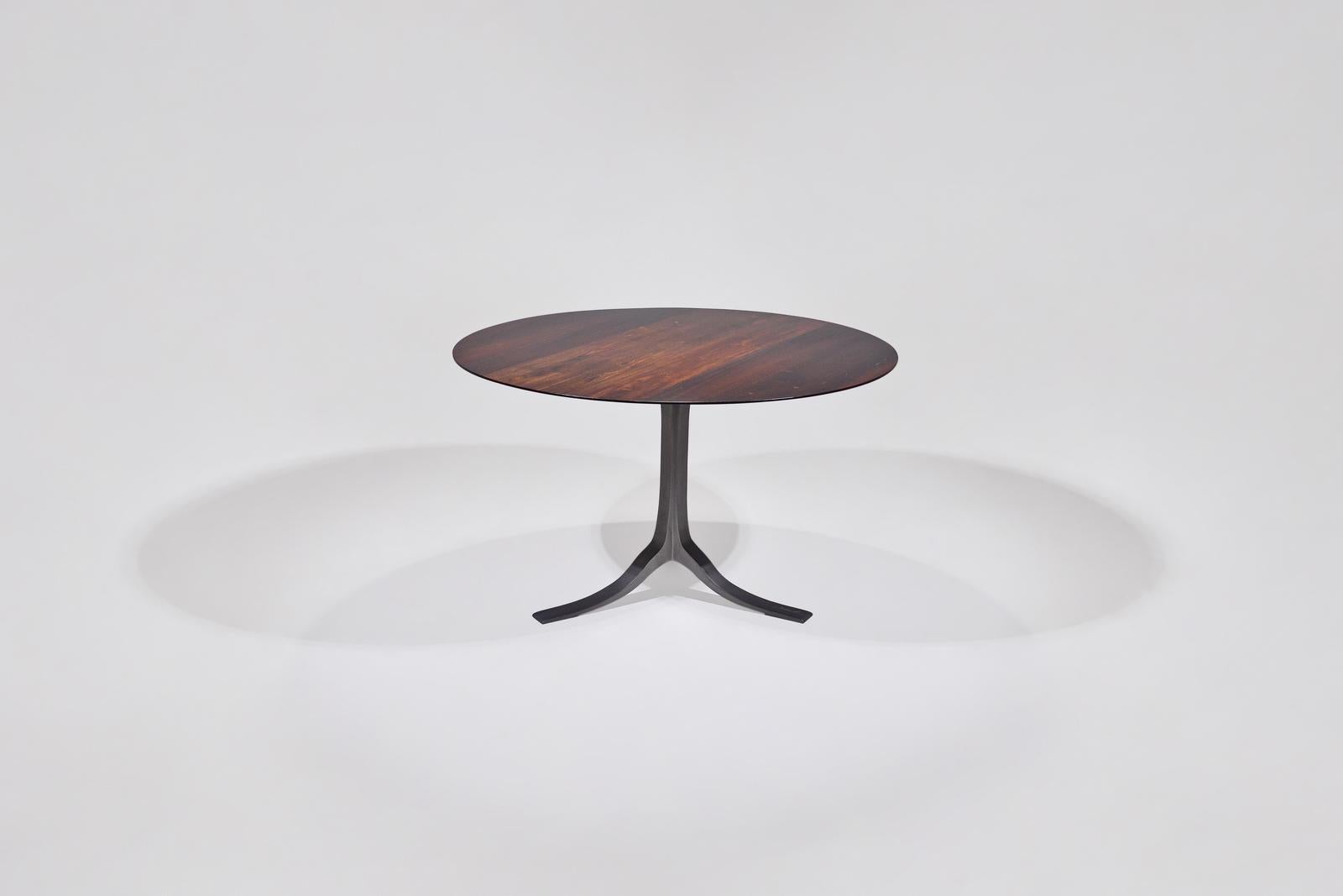 A versatile round table created from reclaimed Makha Tae wood that was once a supporting column of a rice granary. The deep dark tone of the Makha Tae wood set to match with brushed charcoal aluminum base. With a thin sleek beveled profile, the