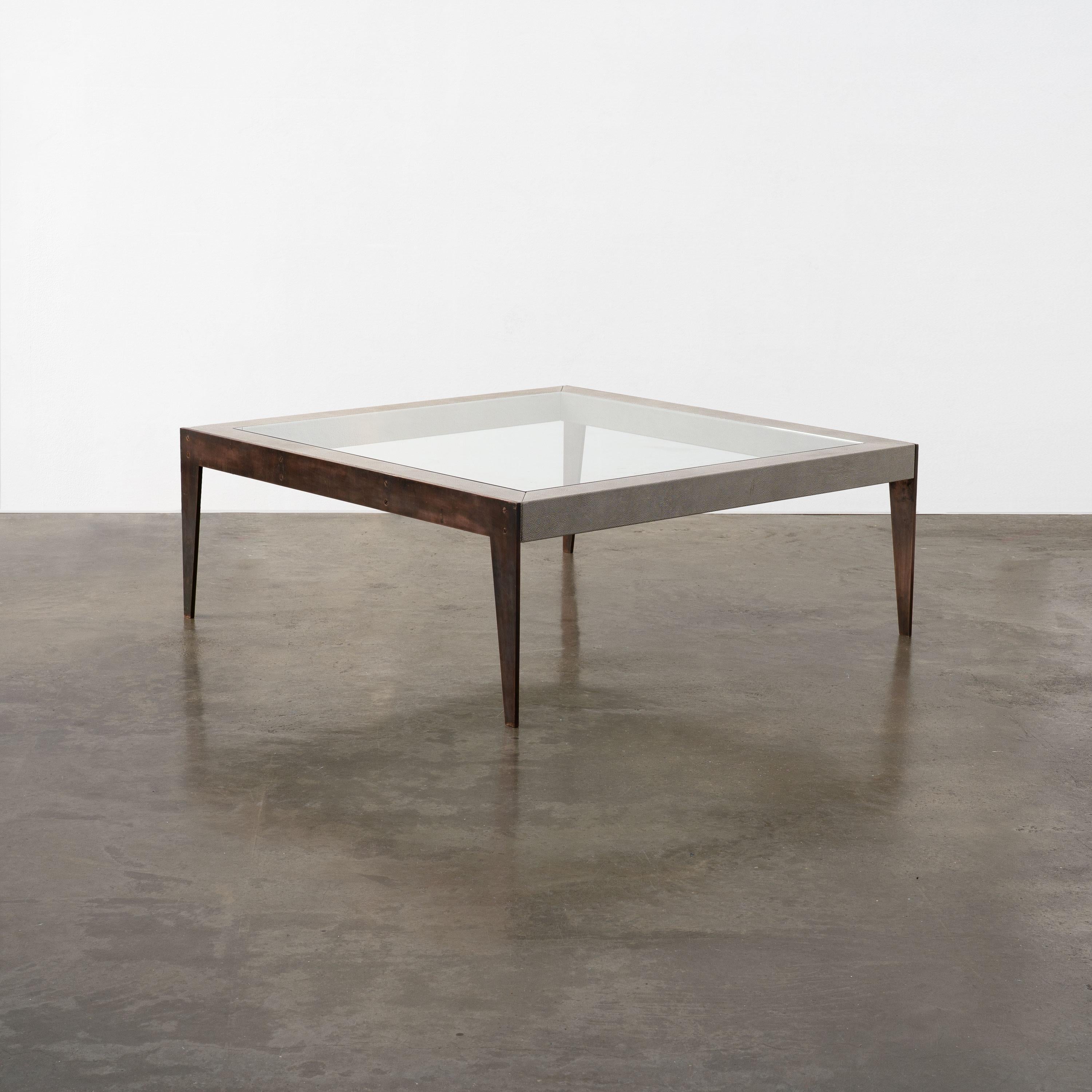 Una mesa de centro contemporánea, hecha a medida, compuesta por un armazón tapizado en piel de raya, patas de latón patinado y una tapa de cristal. 

Dimensiones (cm, aprox.)
Altura: 45
Anchura: 120
Profundidad: 120

Estado: En buen estado, con