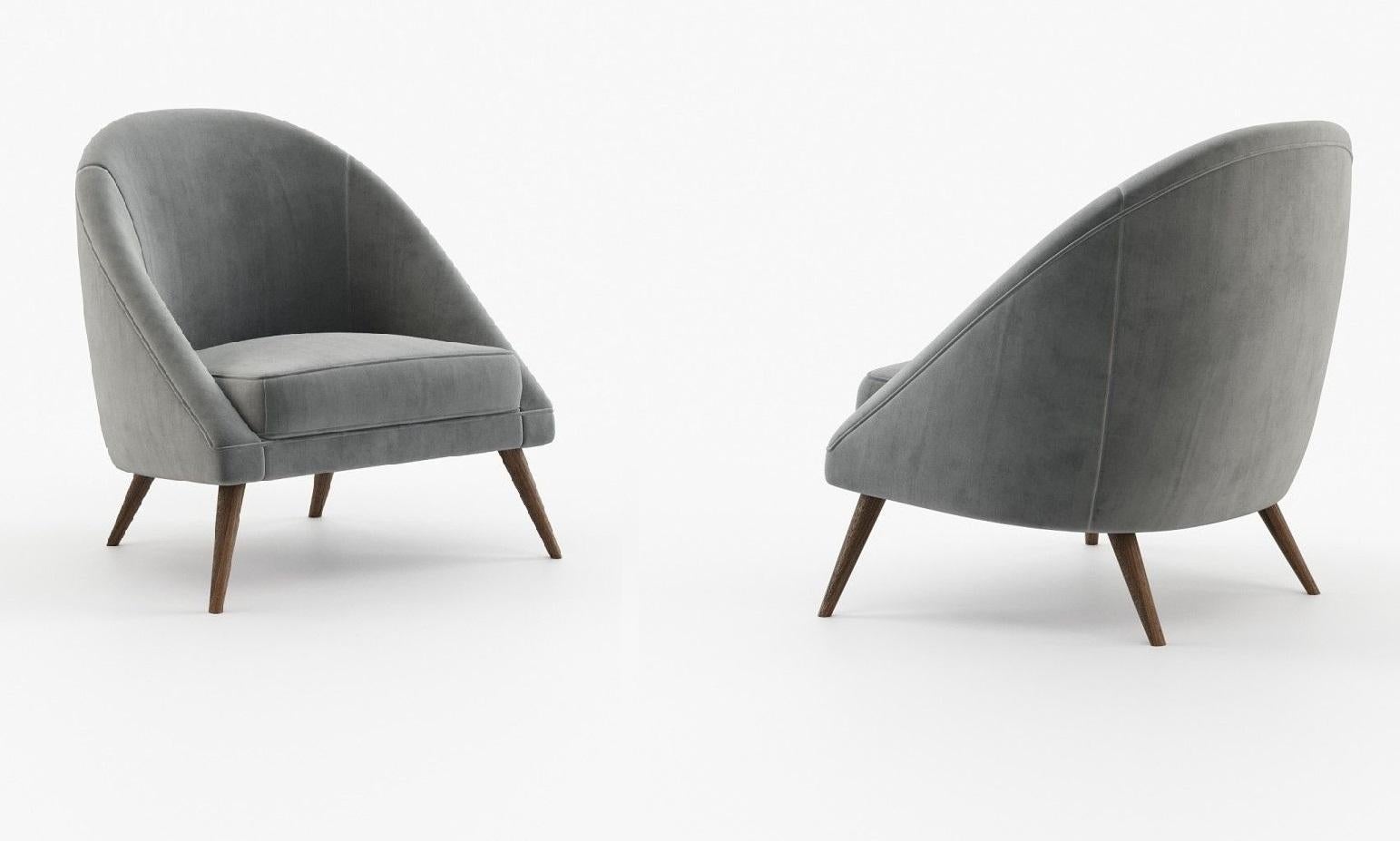 This armchair is a stylish and comfortable addition to any living space. Featuring a mid-century modern design with a contemporary twist, this armchair is fully upholstered and offers a cozy seating experience. It has a deep convex back and angled