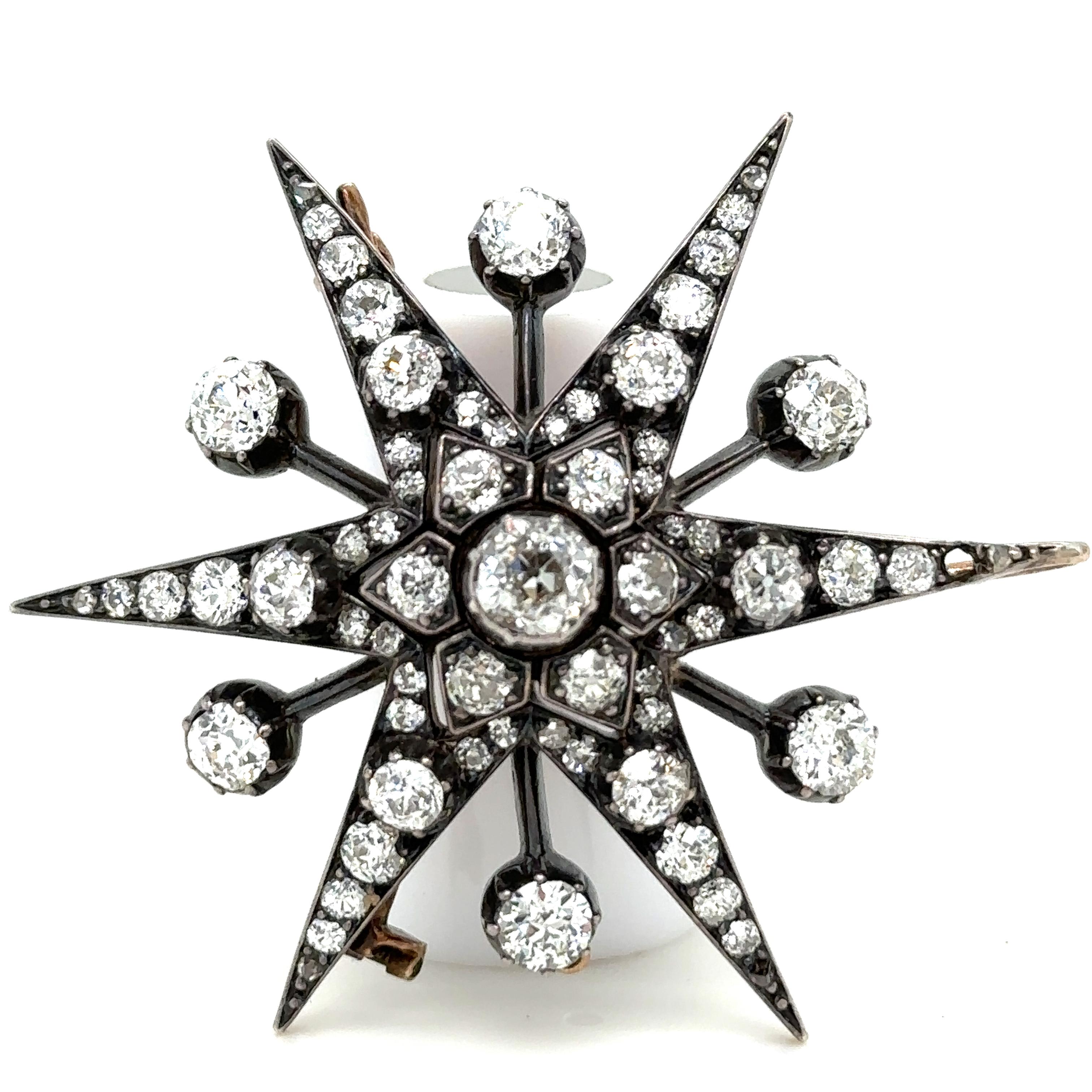 A Victorian Old Cut Diamond Starburst Pendant/Brooch, with 66 old cut diamonds pavé set in silver on 15ct yellow gold. 9ct gold pendant fitting.

Diamonds 1 = 1.00ct (estimated), Graded in setting as Colour: H to I, Clarity: VS

6 = 2.70ct