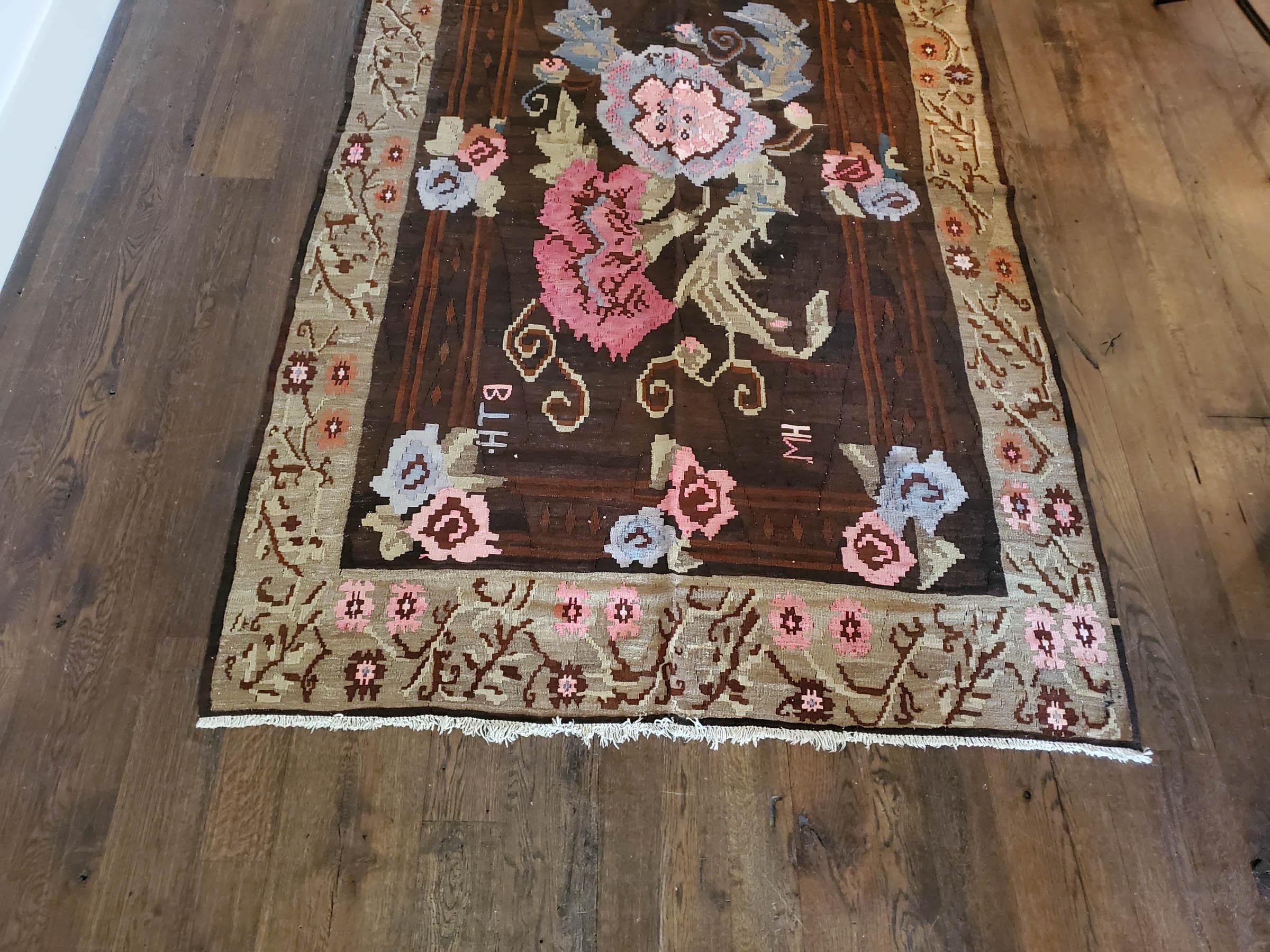 Floral bessarabian design. A hardy strong flat-weave with elaborate pink flowers floating and smaller blossoms in pale blue, ivory, and brown.