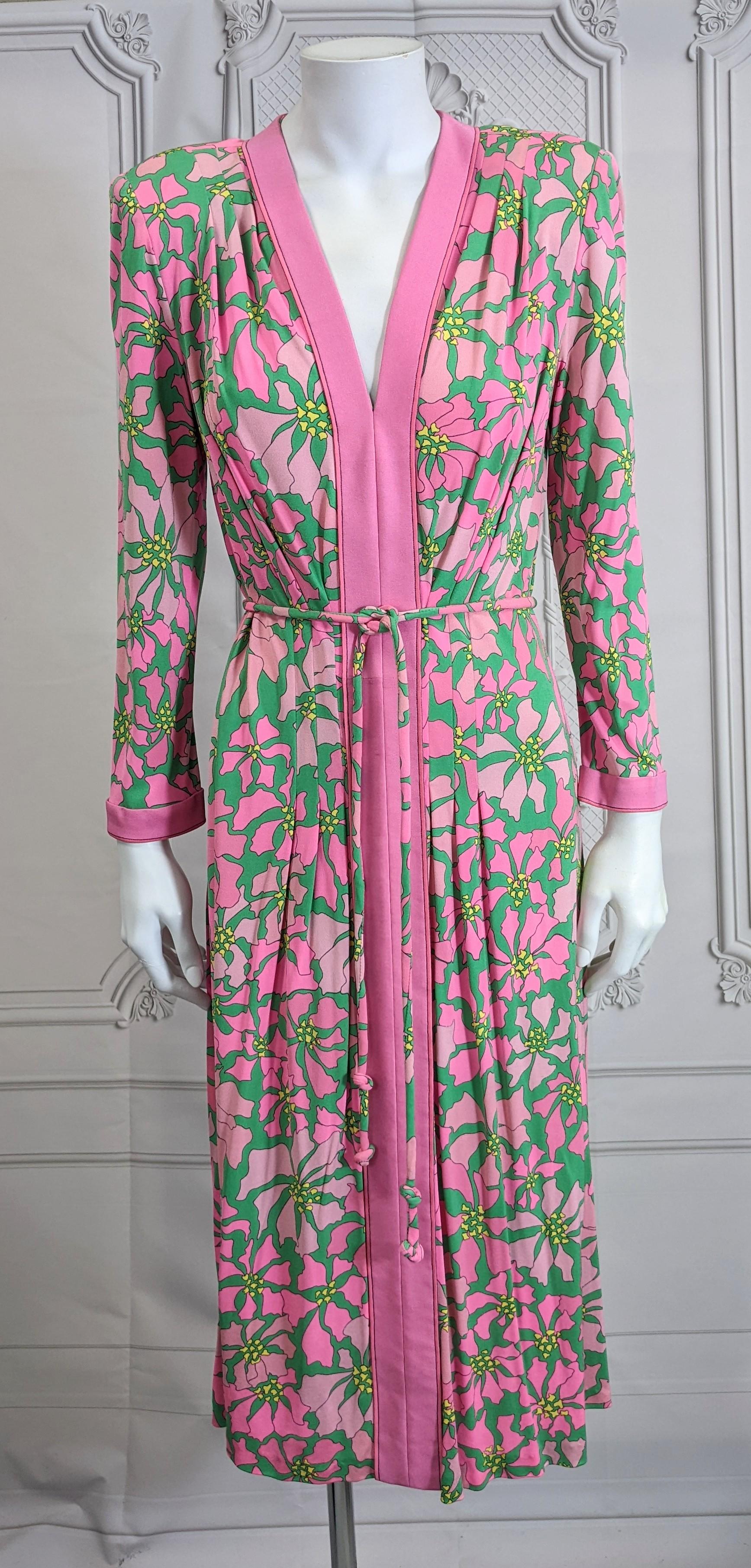 Elegant Bessi Silk Jersey Floral Print Dress with a poinsettia print in vibrant pink and green tones. Easy back zip entry with placed print and self fabric tube belt. Slight shoulder pads with tucks. Tucks also placed at waist for shaping.  
1970's