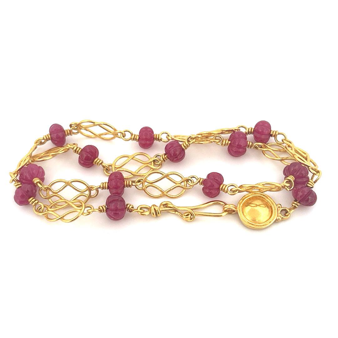 Questa squisita collana di Bessie Jamieson è realizzata a mano in ricco oro giallo 22k e mostra un delicato gioco di arte ed eleganza. Caratterizzato da perle di rubino intricatamente intagliate, ogni gemma ha una forma unica, che emana calore e