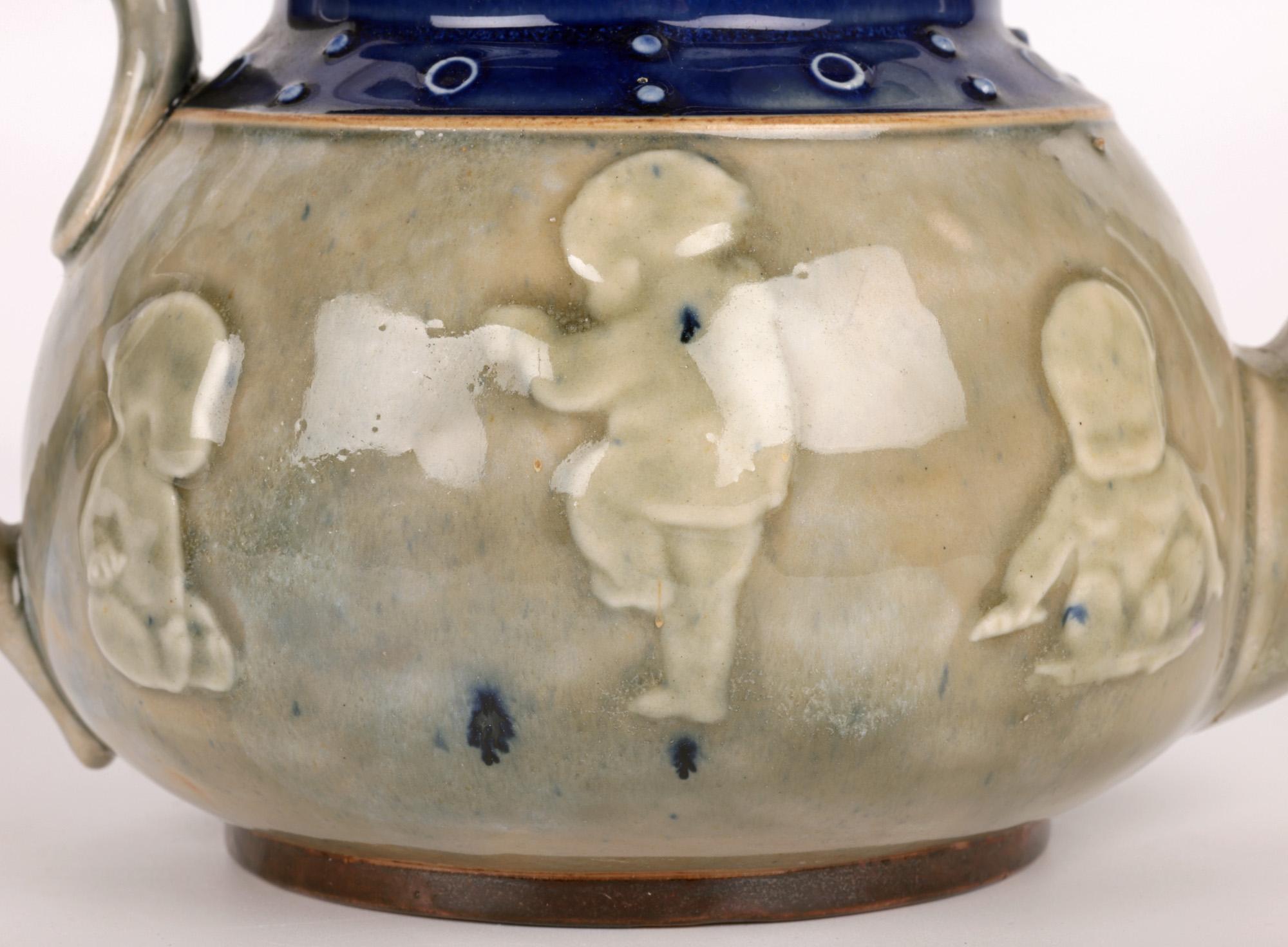 A very fine and stylish Art Deco Doulton Lambeth teapot decorated in relief with babies by renowned artist Bessie Newbery dating from around 1922. The stoneware teapot is a unique work by Newbery who produced a number of original works between 1914