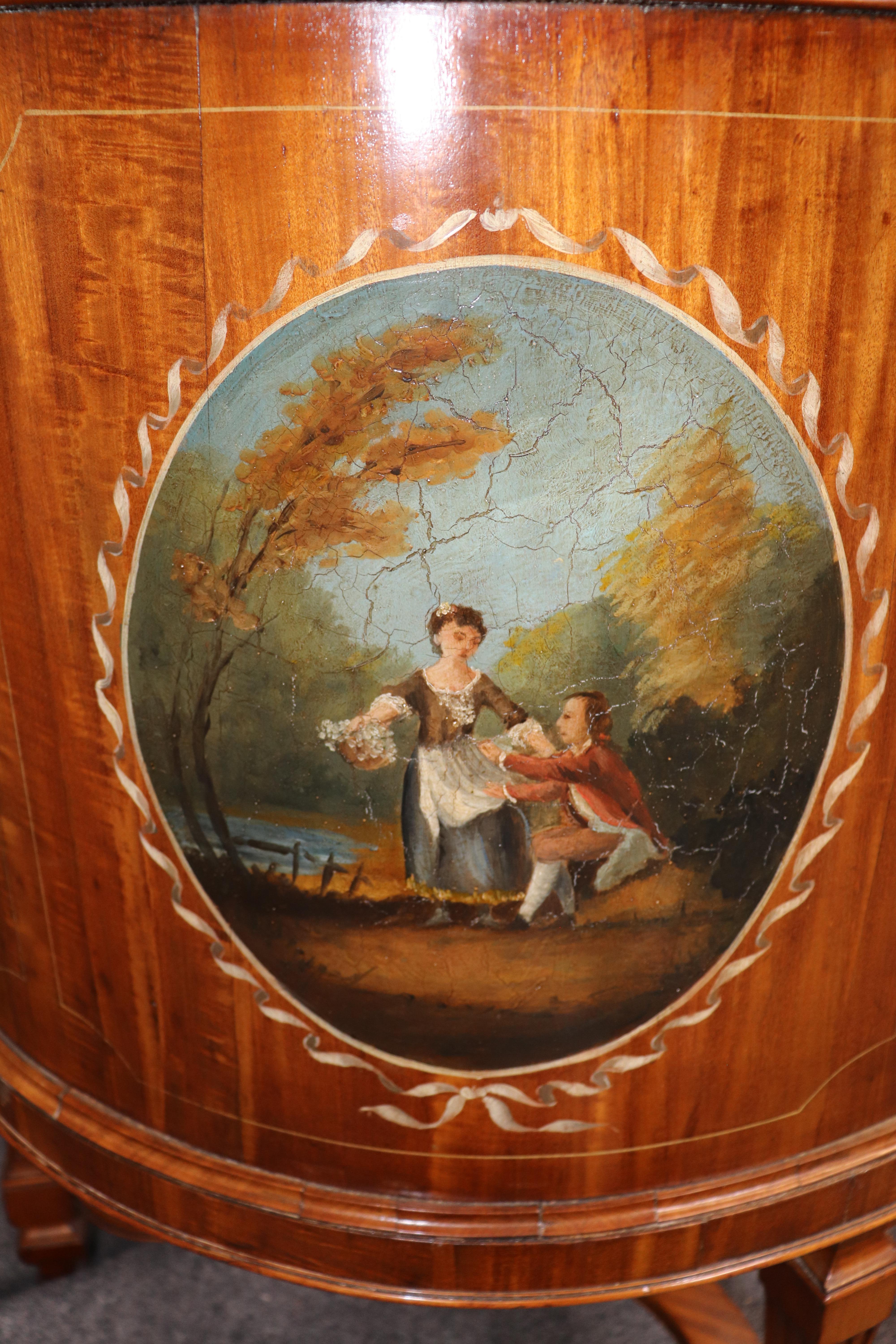 This is breathtakingly beautiful piece of English art masquerading as a writing desk or ladies vanity. The vanity is painted in the Adams style depicting a man and woman in a courtship scene. The paint decorations and crackled age to the finish