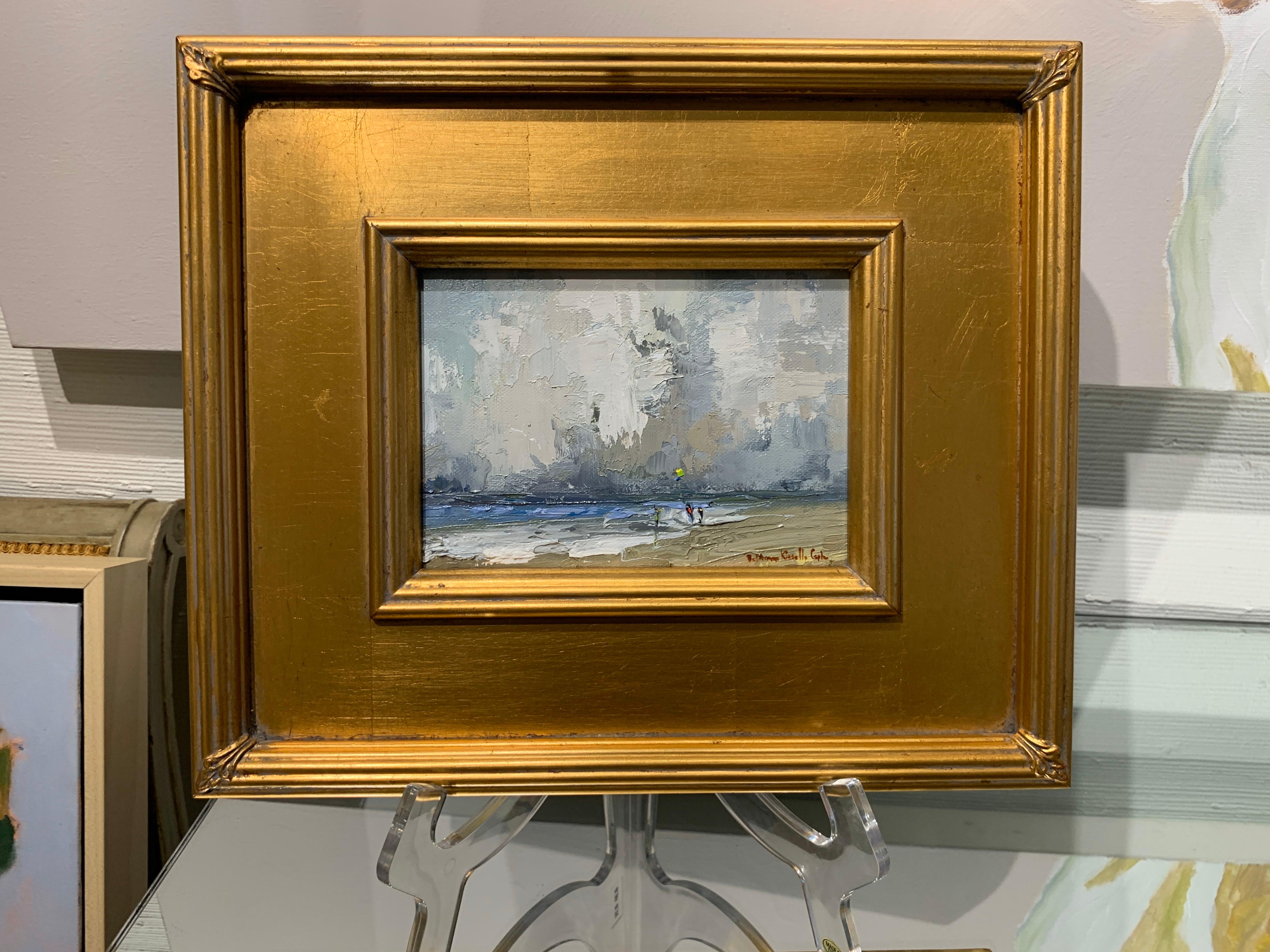 'Where the Sun Forgets the Day' is a petite framed Impressionist oil on board beach painting created by American artist Bethanne Kinsella Cople in 2019. Featuring a subtle palette, mostly made of blue and brown tones, delicately highlighted by