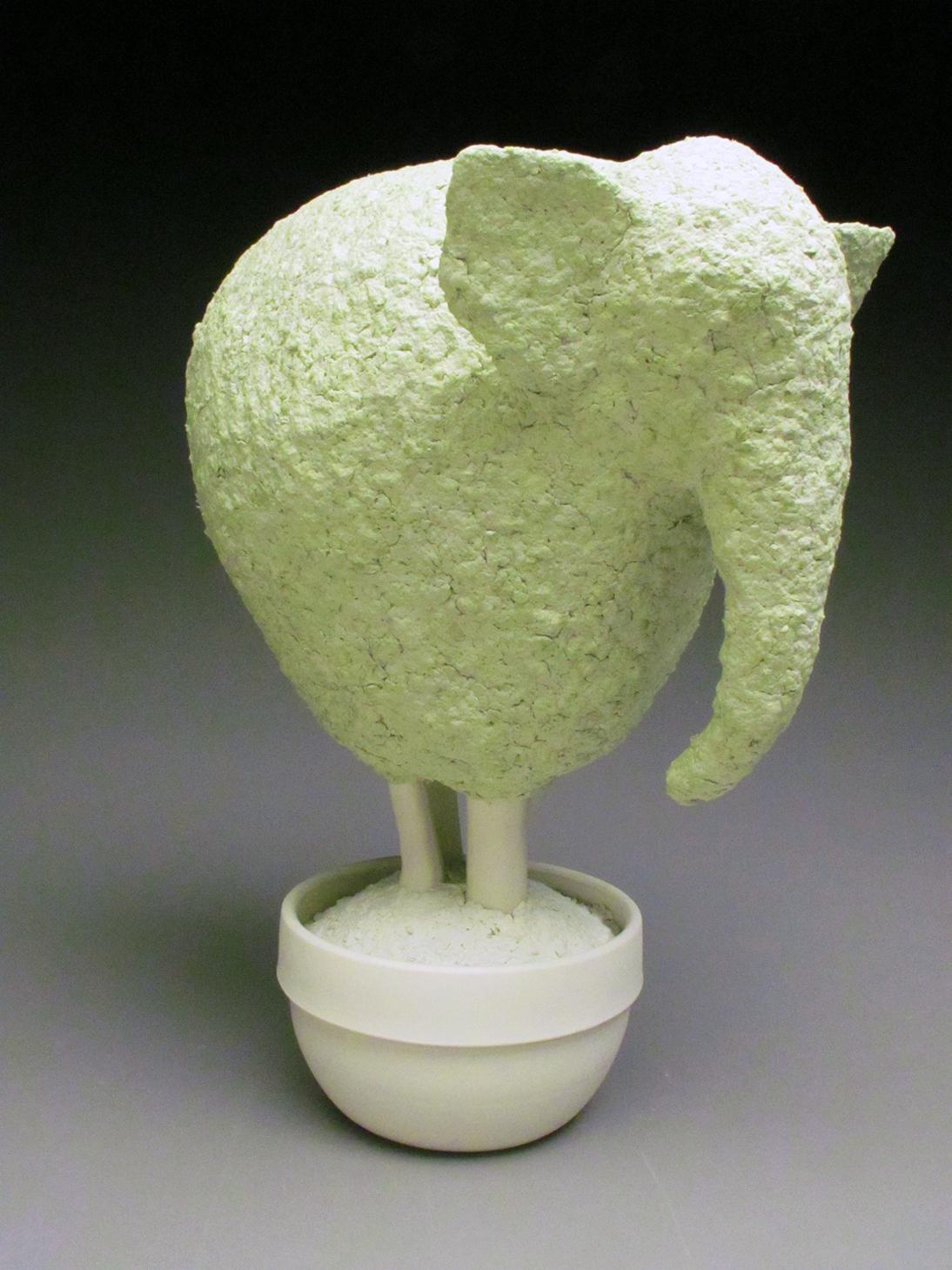 Esta preciosa escultura topiaria de elefante de porcelana y papel maché verde suave fue creada por la artista neoyorquina Bethany Krull.  La parte de la escultura que corresponde a la vasija está moldeada en varias piezas, mientras que el Topiario