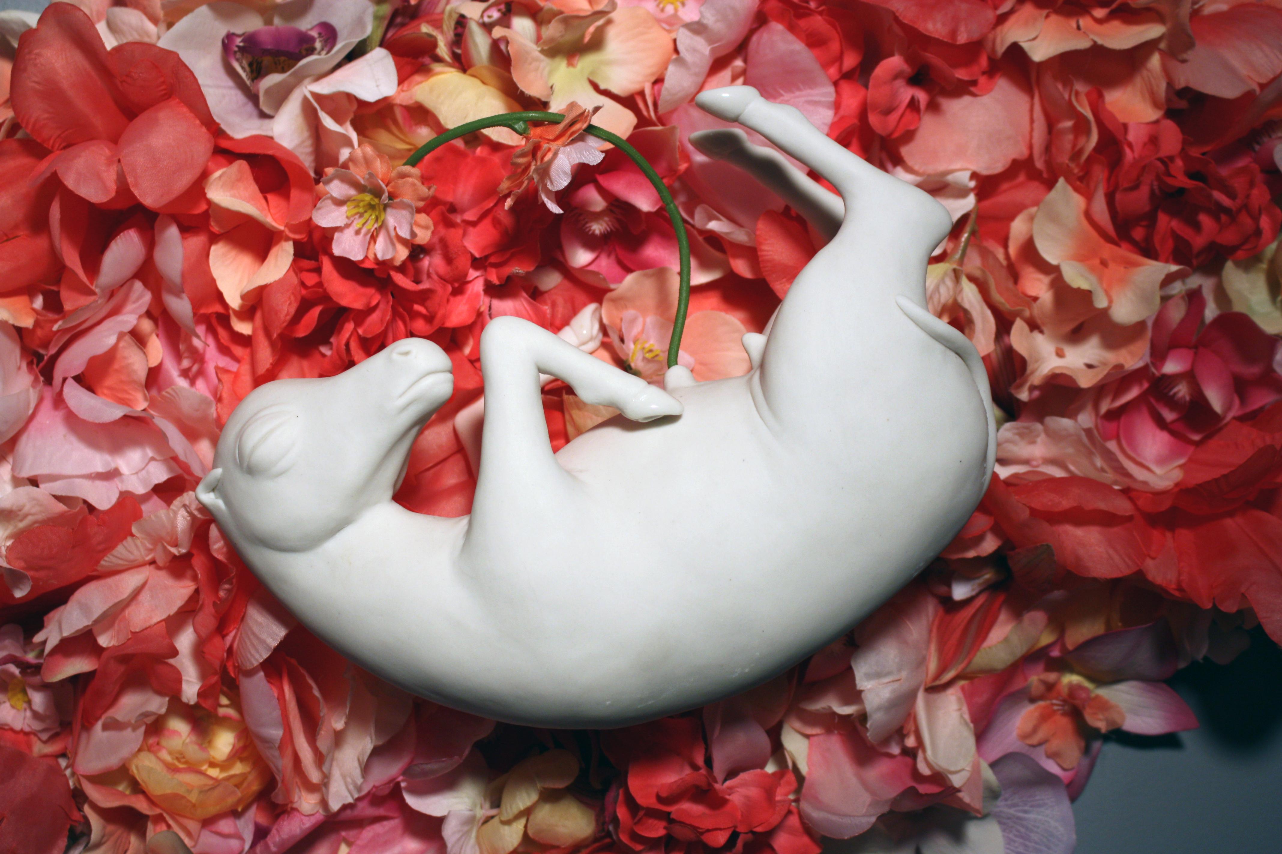 Cette sculpture murale de cheval en porcelaine est fabriquée à la main, sans utiliser de moules, par l'artiste new-yorkaise Bethany Krull. Elle flotte paisiblement dans un nid de fleurs en soie rose. 
