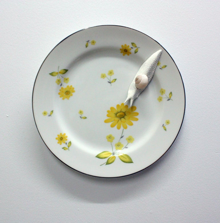 This piece was created with a real found snail shell and durable epoxy clay New York artist, Bethany Krull who sculpts the beautiful snail to traverse the surface of the yellow floral plate.  The glistening wet snail form is surfaced with many