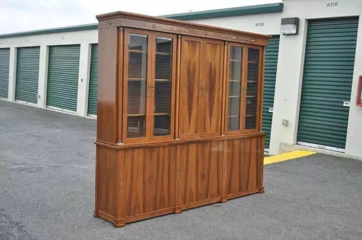 Large Vintage 2 Piece Rosewood Neoclassical/Empire Style Bookcase Breakfront by Bethehem Furniture. Item features 4 beveled glass doors concealing adjustable shelving, brass arrow and wreath mounts, brass mounted ormolu columns, lower swing doors